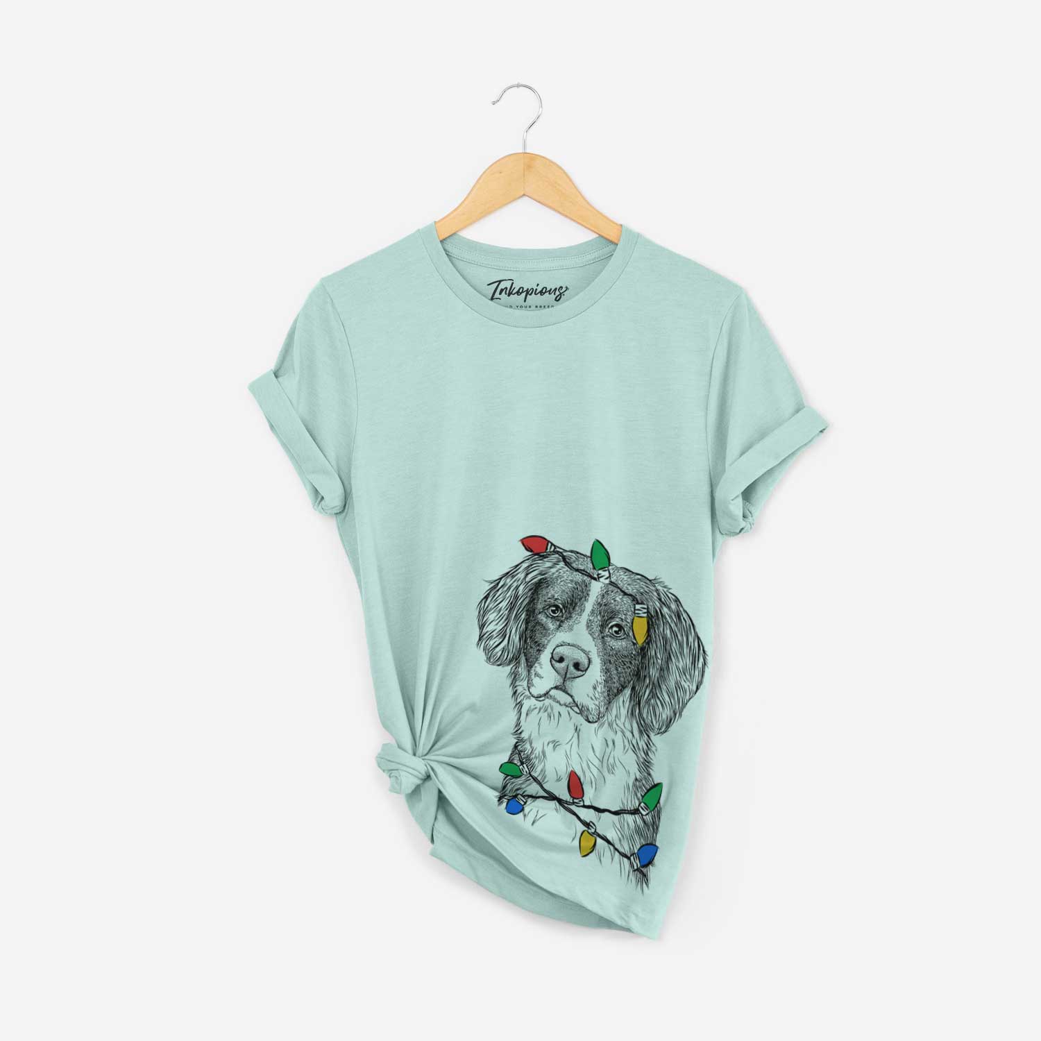 Hand-drawn sketch of Dulce the Drentsche Patrijshond wrapped in Christmas lights on a Heather Sage Unisex crewneck