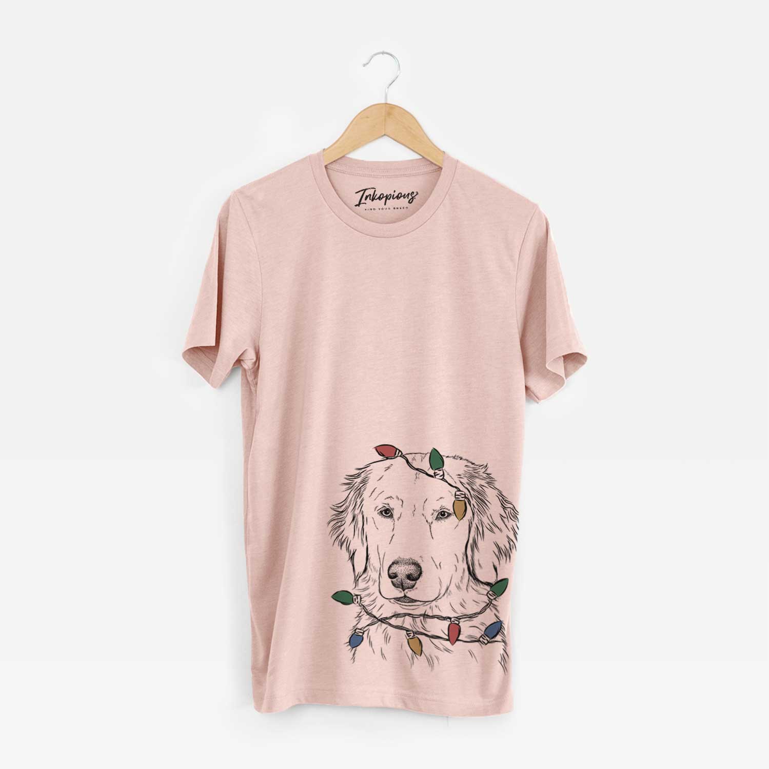 Hand-drawn sketch of Eli the Golden Retriever wrapped in Christmas lights on a Peach Unisex crewneck