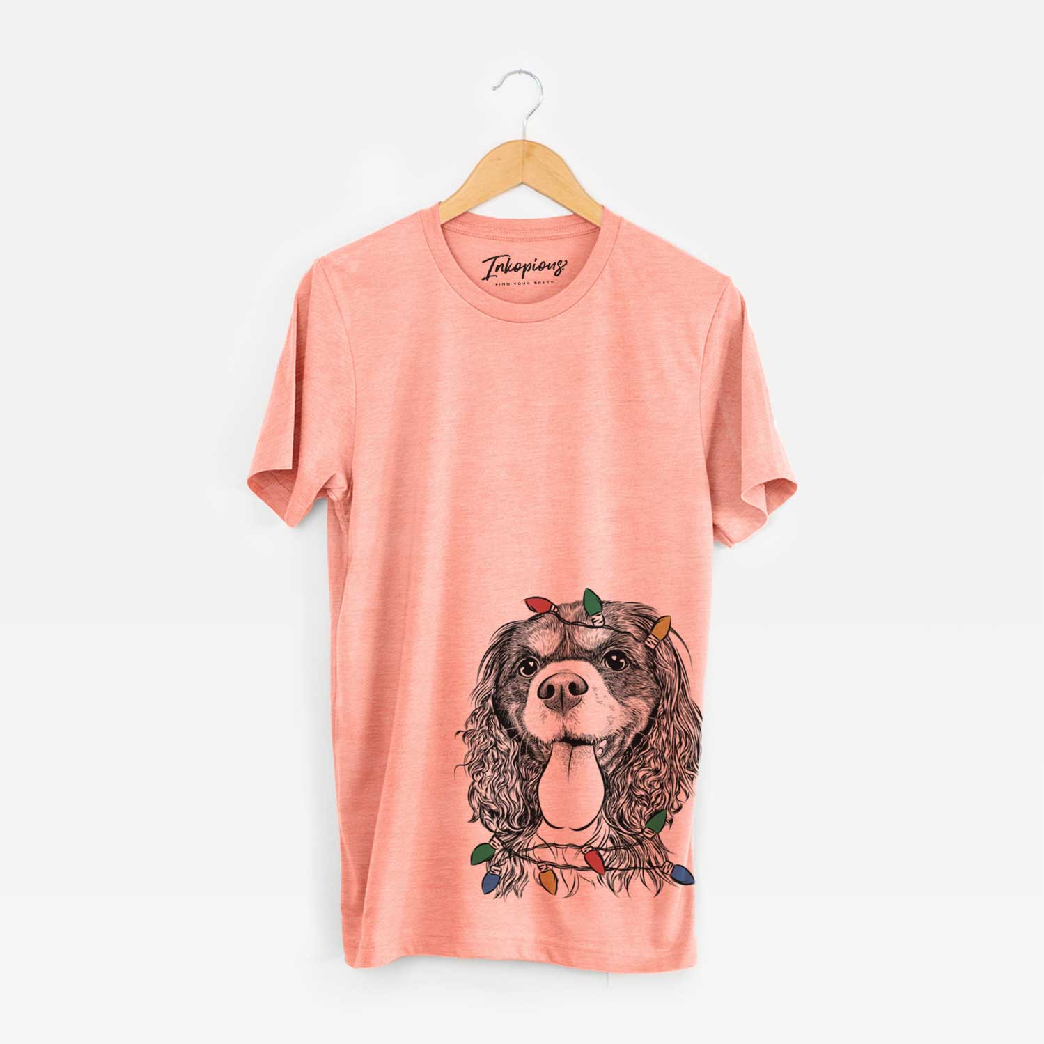 Hand-drawn sketch of Elizabeth the Cavalier King Charles Spaniel wrapped in Christmas lights on a Sunset Unisex crewneck