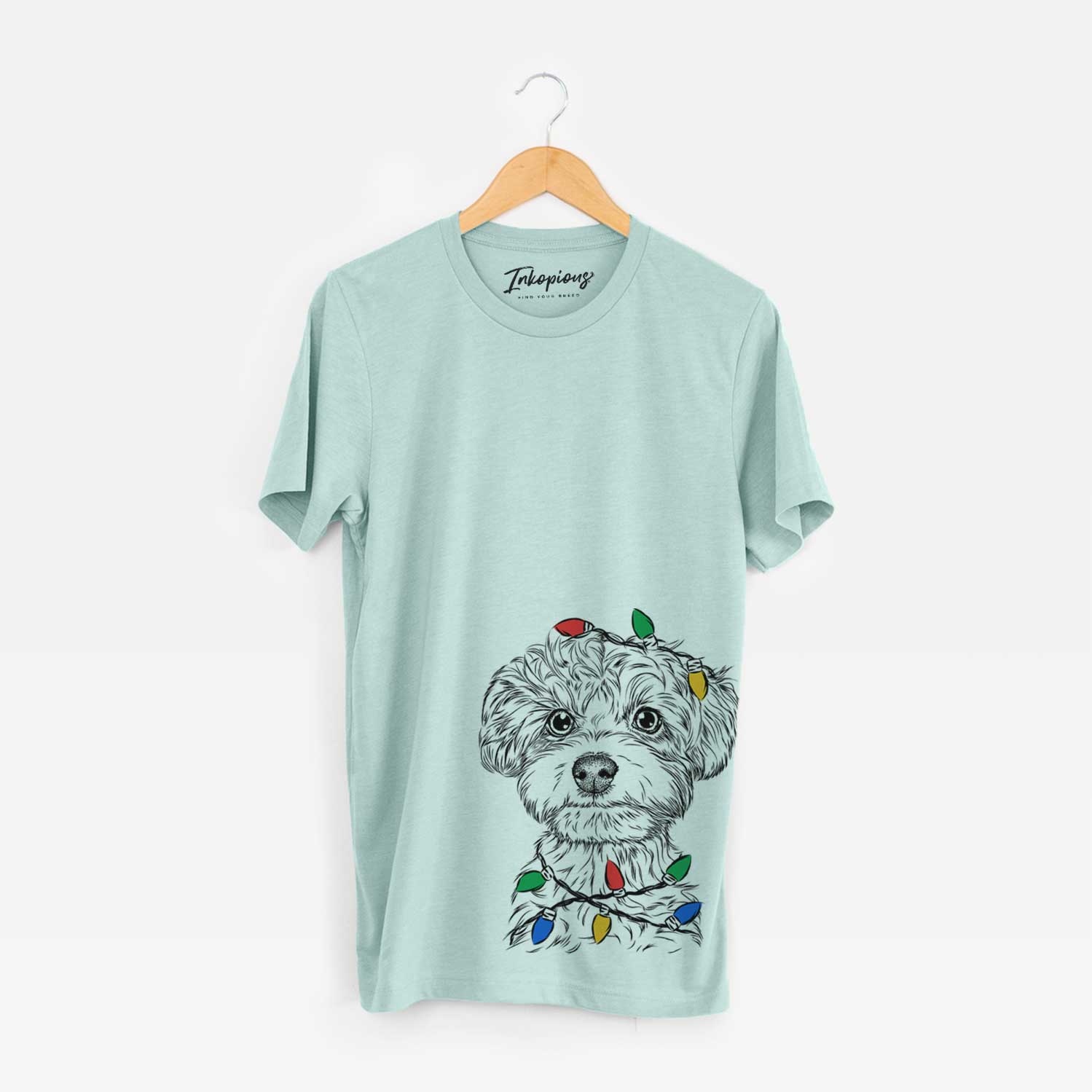 Hand-drawn sketch of Elliott the Yorkiepoo wrapped in Christmas lights on a Heather Sage Unisex crewneck