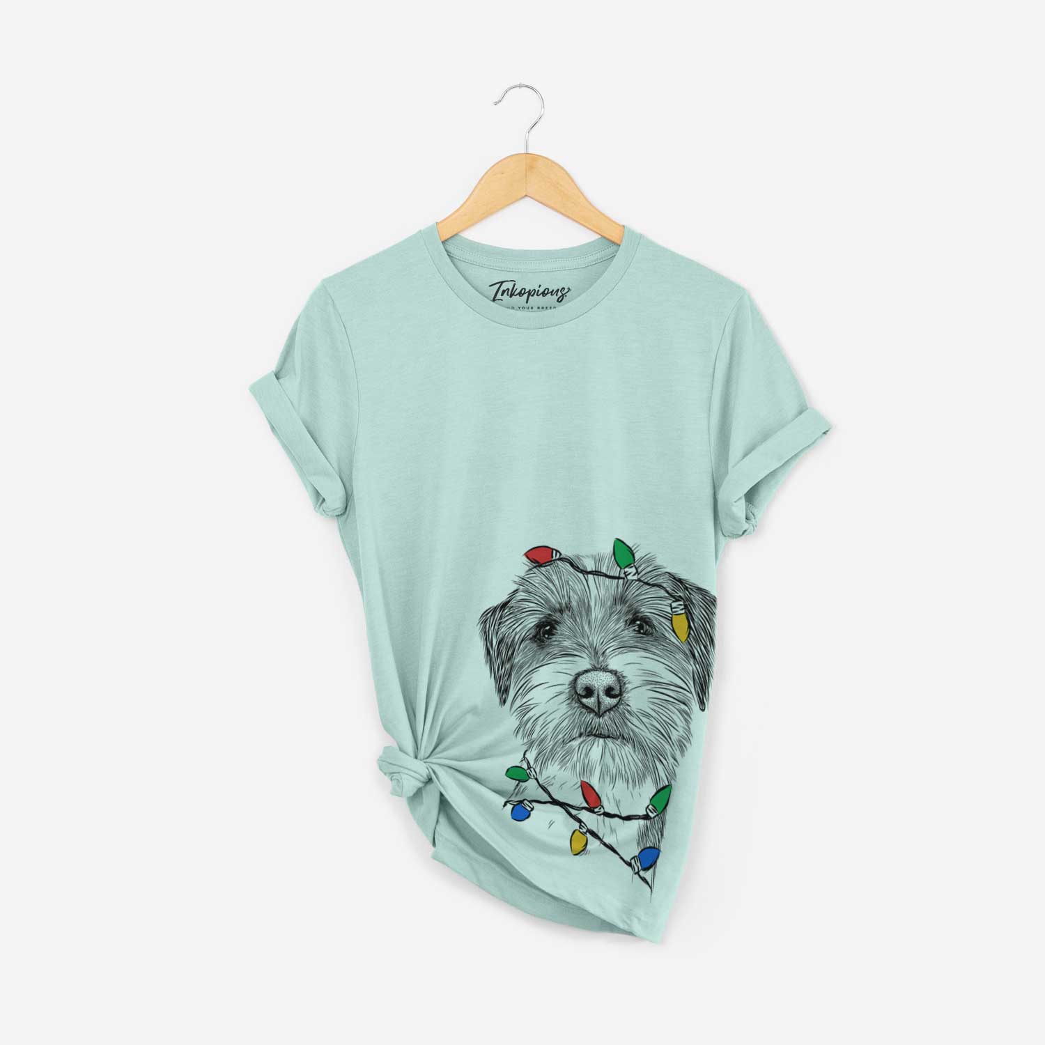 Hand-drawn sketch of Feis the Parson Russell Terrier wrapped in Christmas lights on a Heather Sage Unisex crewneck