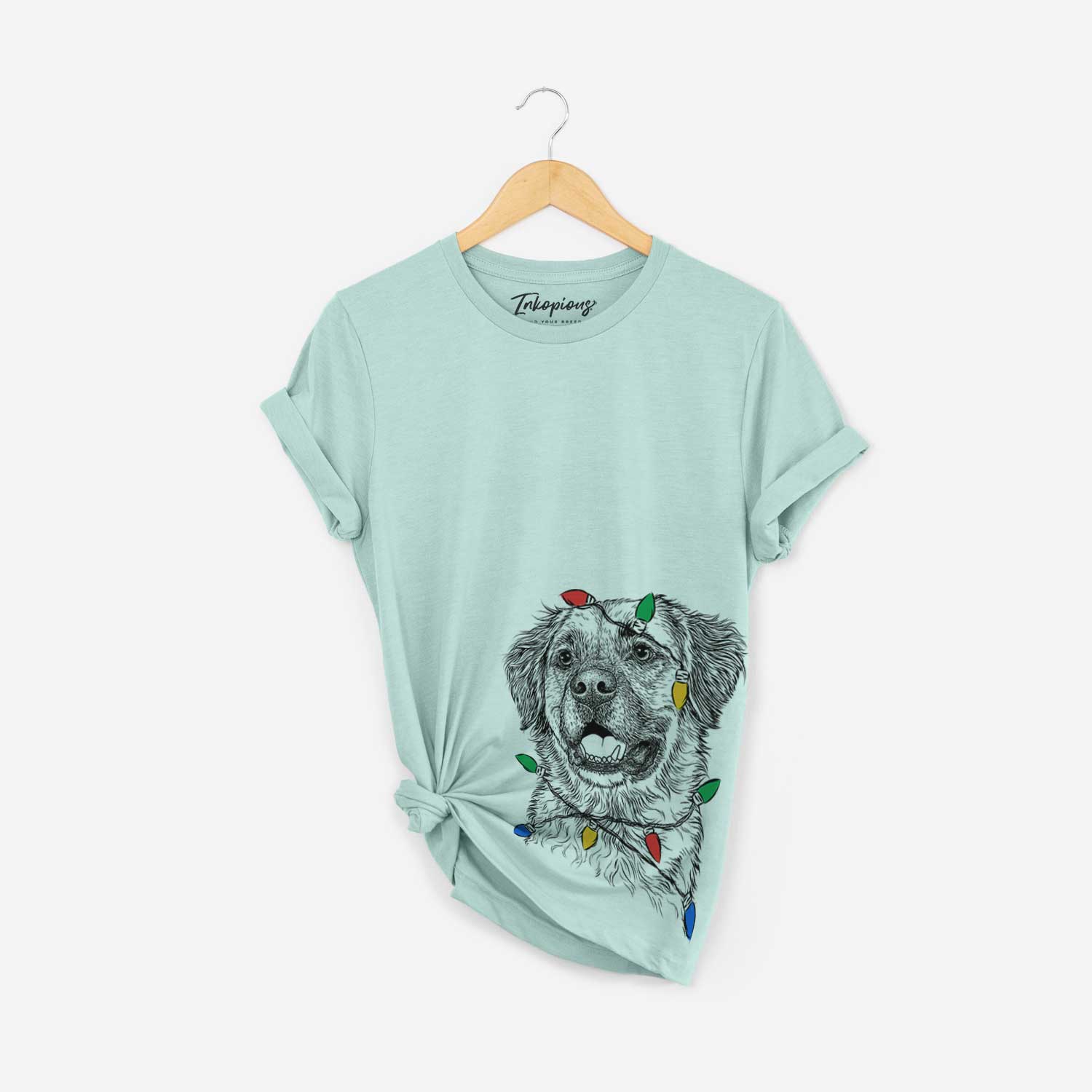 Hand-drawn sketch of Finn the Mixed Breed wrapped in Christmas lights on a Heather Sage Unisex crewneck