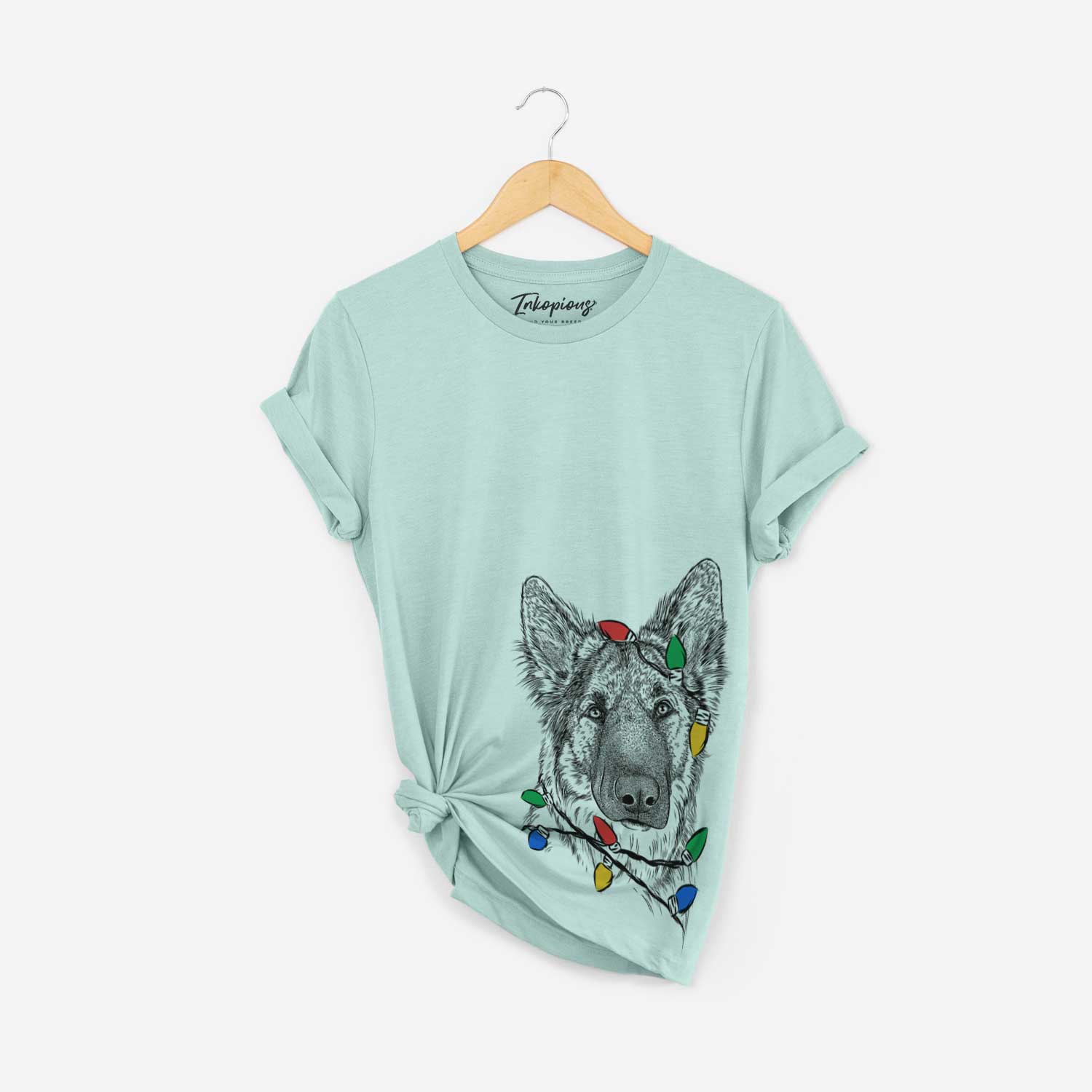 Hand-drawn sketch of Geddy the Shiloh Shepherd wrapped in Christmas lights on a Heather Sage Unisex crewneck
