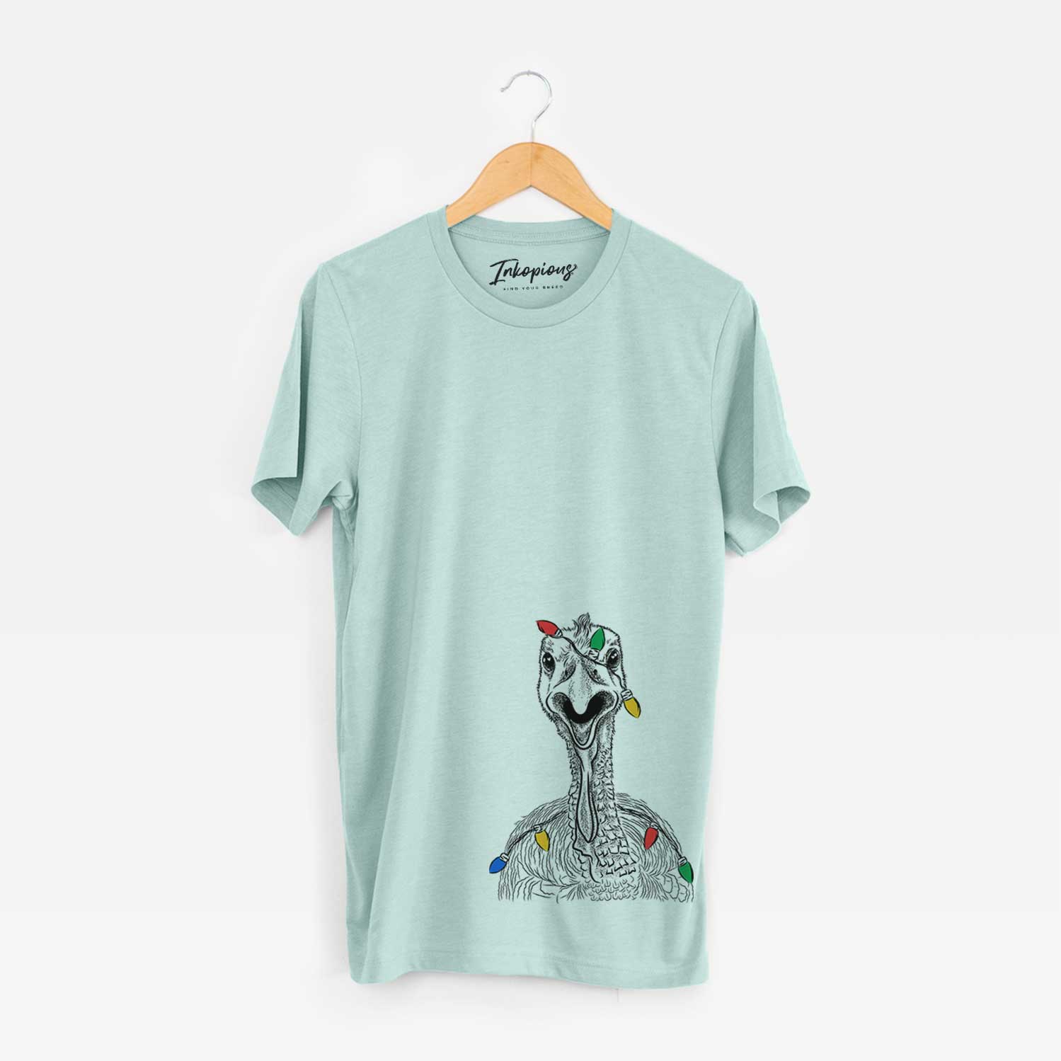 Hand-drawn sketch of Gobble the Turkey wrapped in Christmas lights on a Heather Sage Unisex crewneck