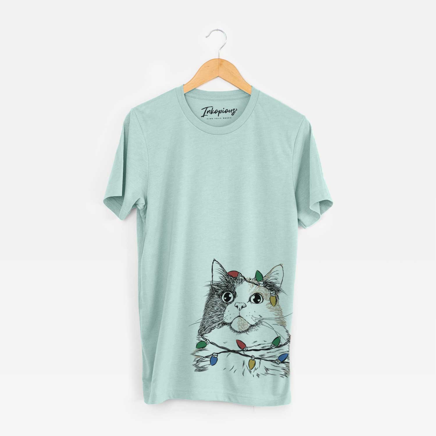 Hand-drawn sketch of Greta the Calico Cat wrapped in Christmas lights on a Heather Sage Unisex crewneck