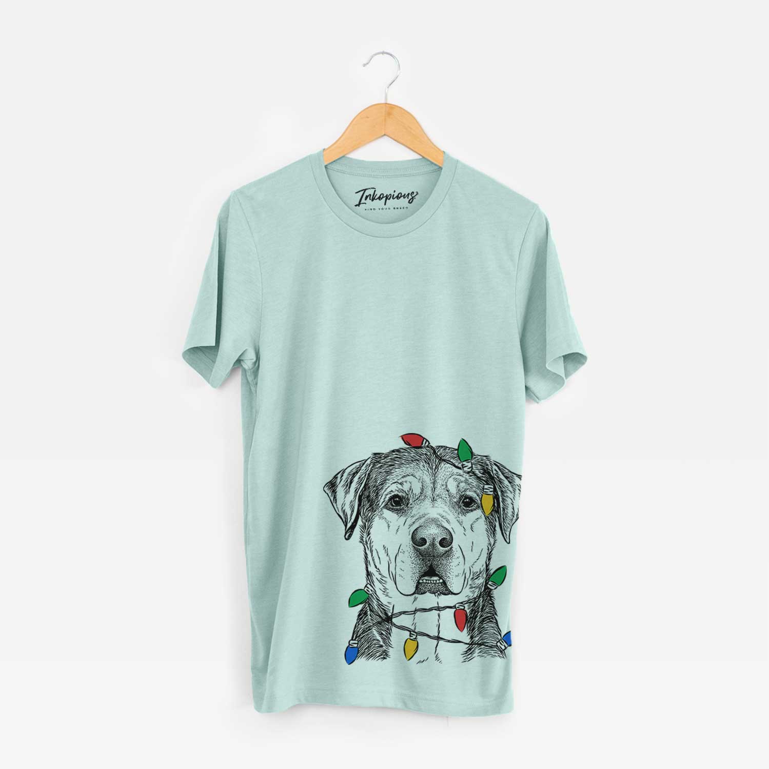 Hand-drawn sketch of Gus the Rottweiler Mix wrapped in Christmas lights on a Heather Sage Unisex crewneck
