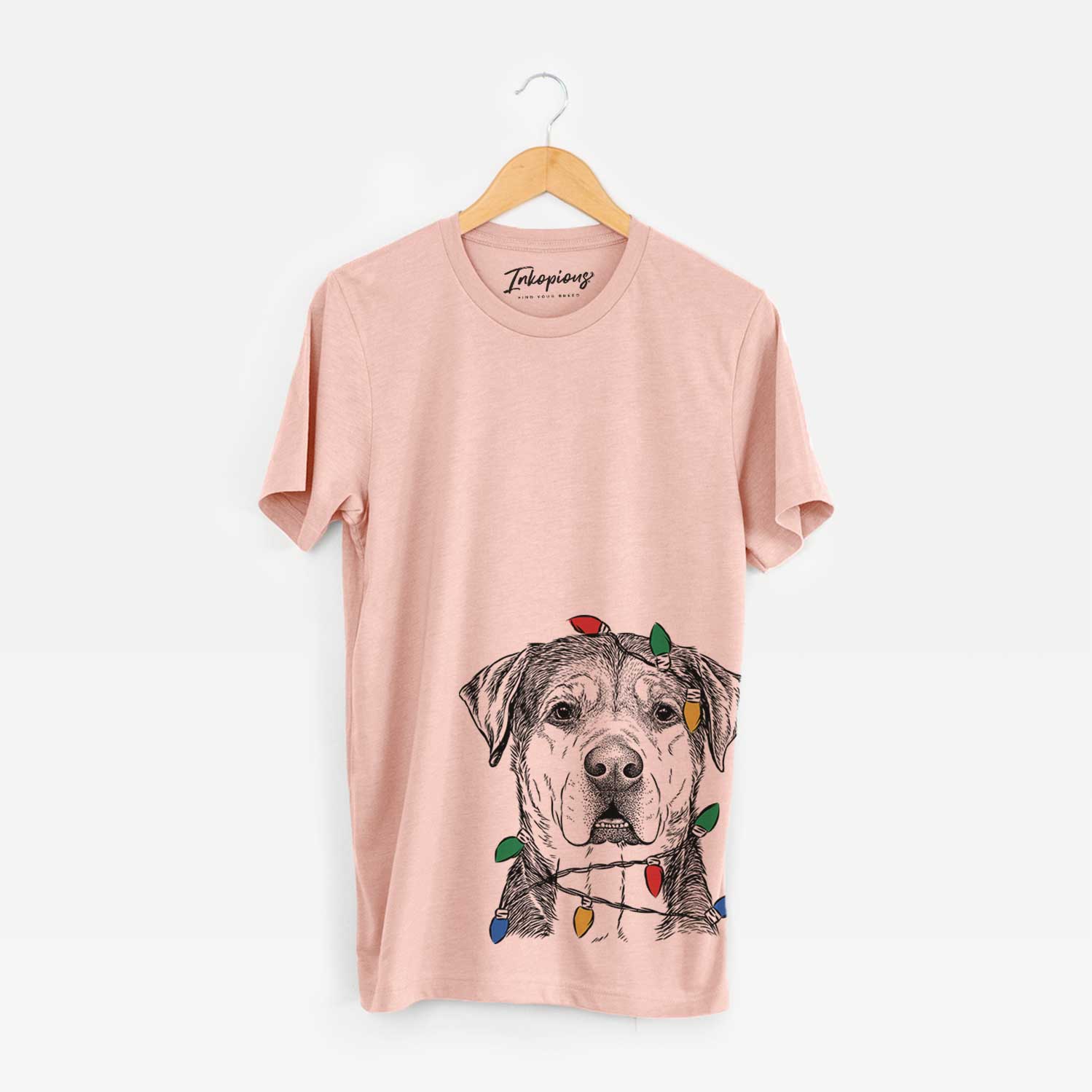 Hand-drawn sketch of Gus the Rottweiler Mix wrapped in Christmas lights on a Peach Unisex crewneck