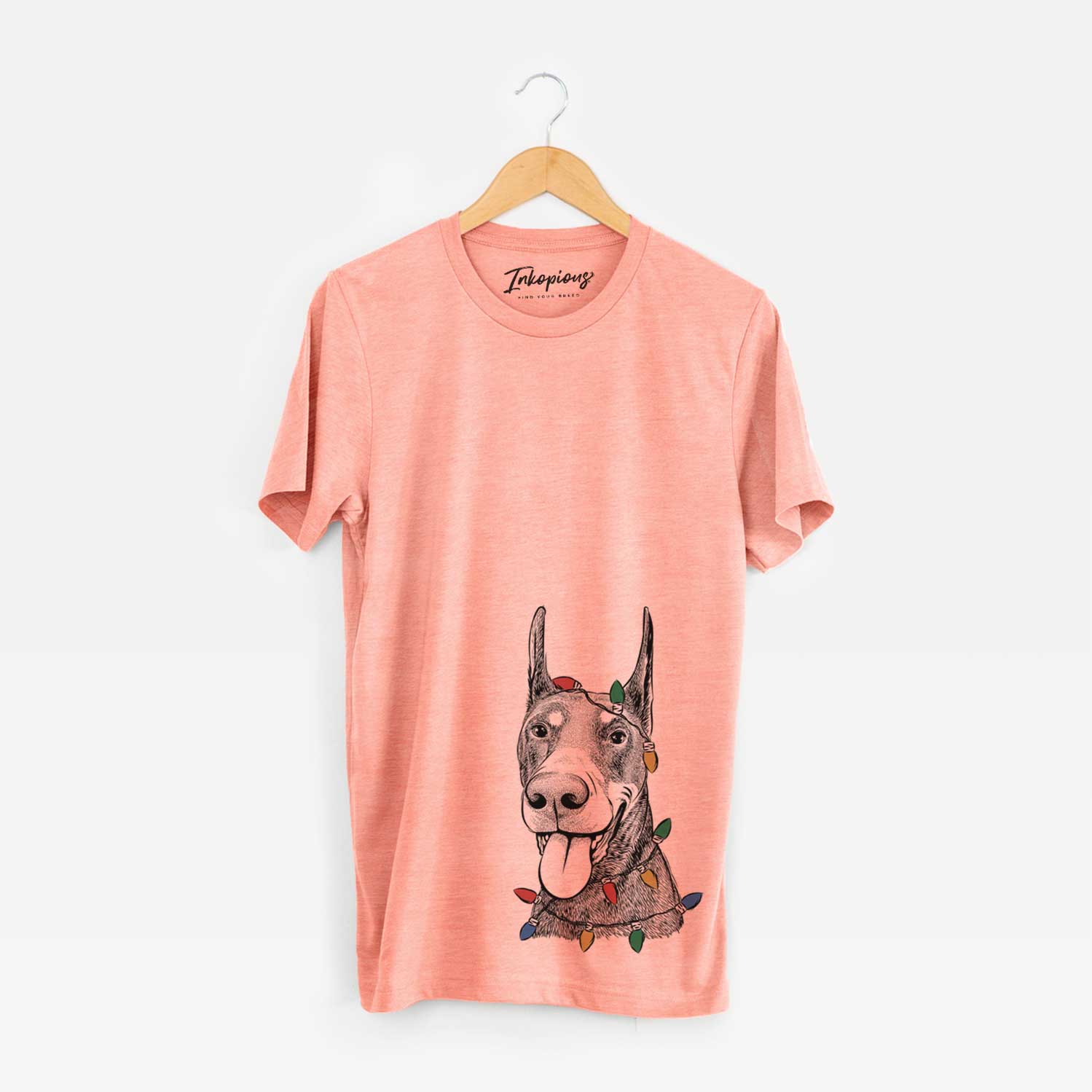 Hand-drawn sketch of Happy Sunny the Doberman Pinscher wrapped in Christmas lights on a Sunset Unisex crewneck