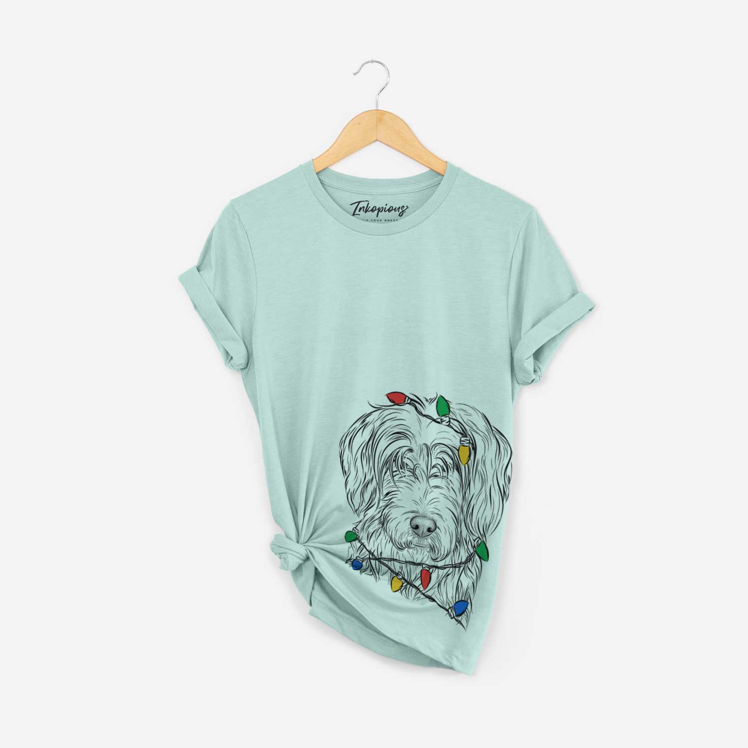 Hand-drawn sketch of Harry the Mixed Breed wrapped in Christmas lights on a Heather Sage Unisex crewneck