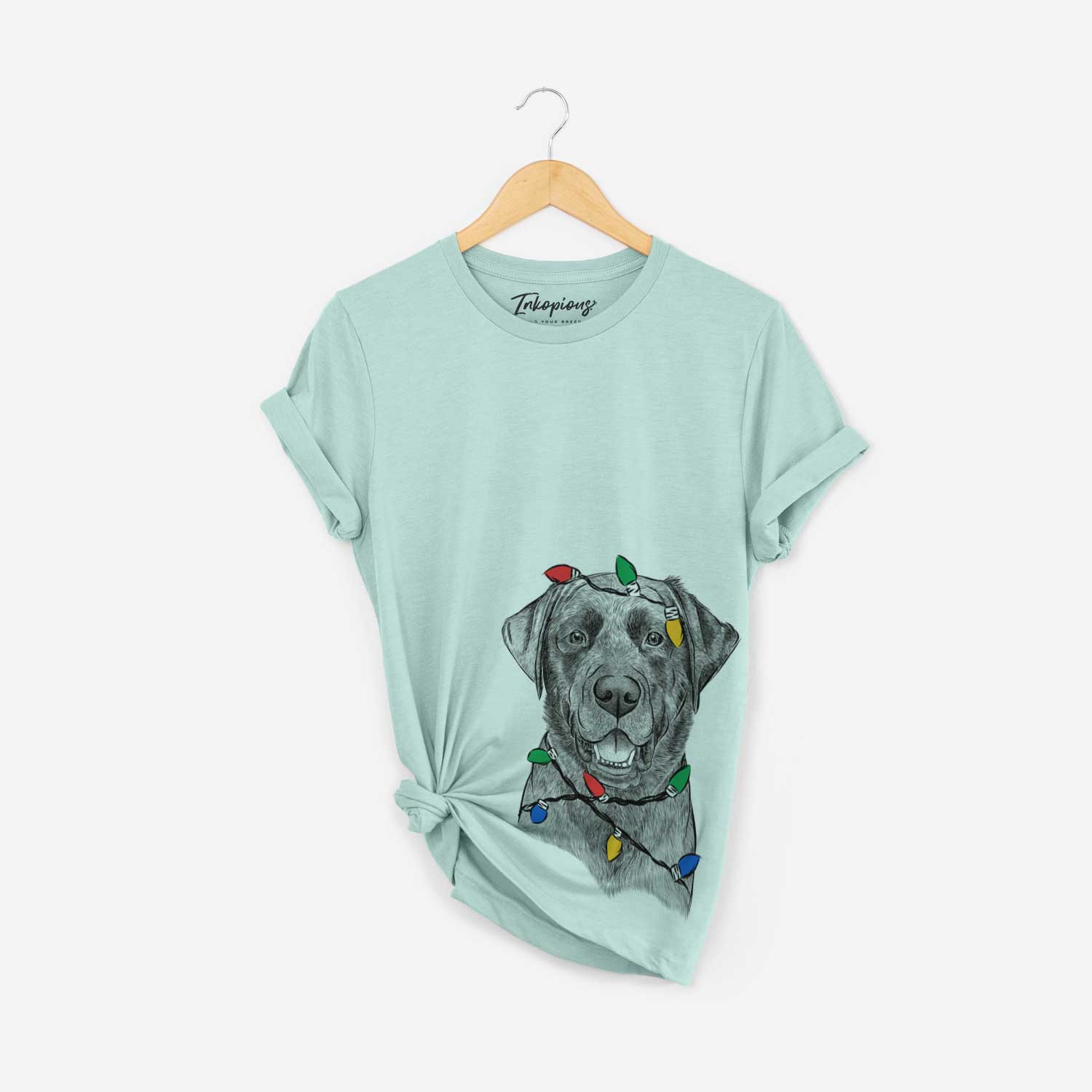 Hand-drawn sketch of Heath the Black Lab wrapped in Christmas lights on a Heather Sage Unisex crewneck