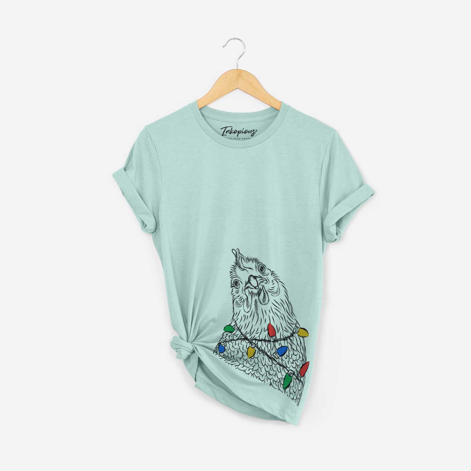 Hand-drawn sketch of Henrietta the Chicken wrapped in Christmas lights on a Heather Sage Unisex crewneck