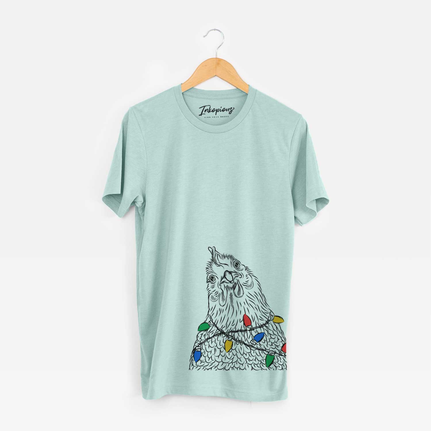 Hand-drawn sketch of Henrietta the Chicken wrapped in Christmas lights on a Heather Sage Unisex crewneck