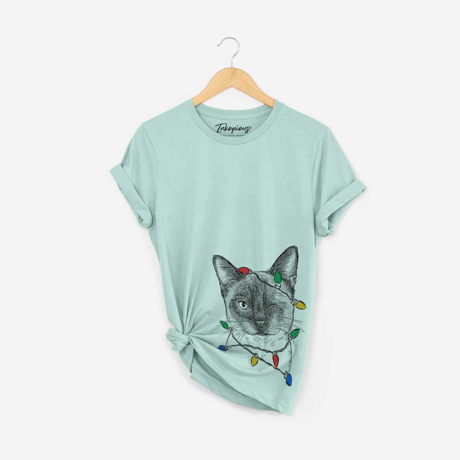 Hand-drawn sketch of Hoggle the Siamese Cat wrapped in Christmas lights on a Heather Sage Unisex crewneck