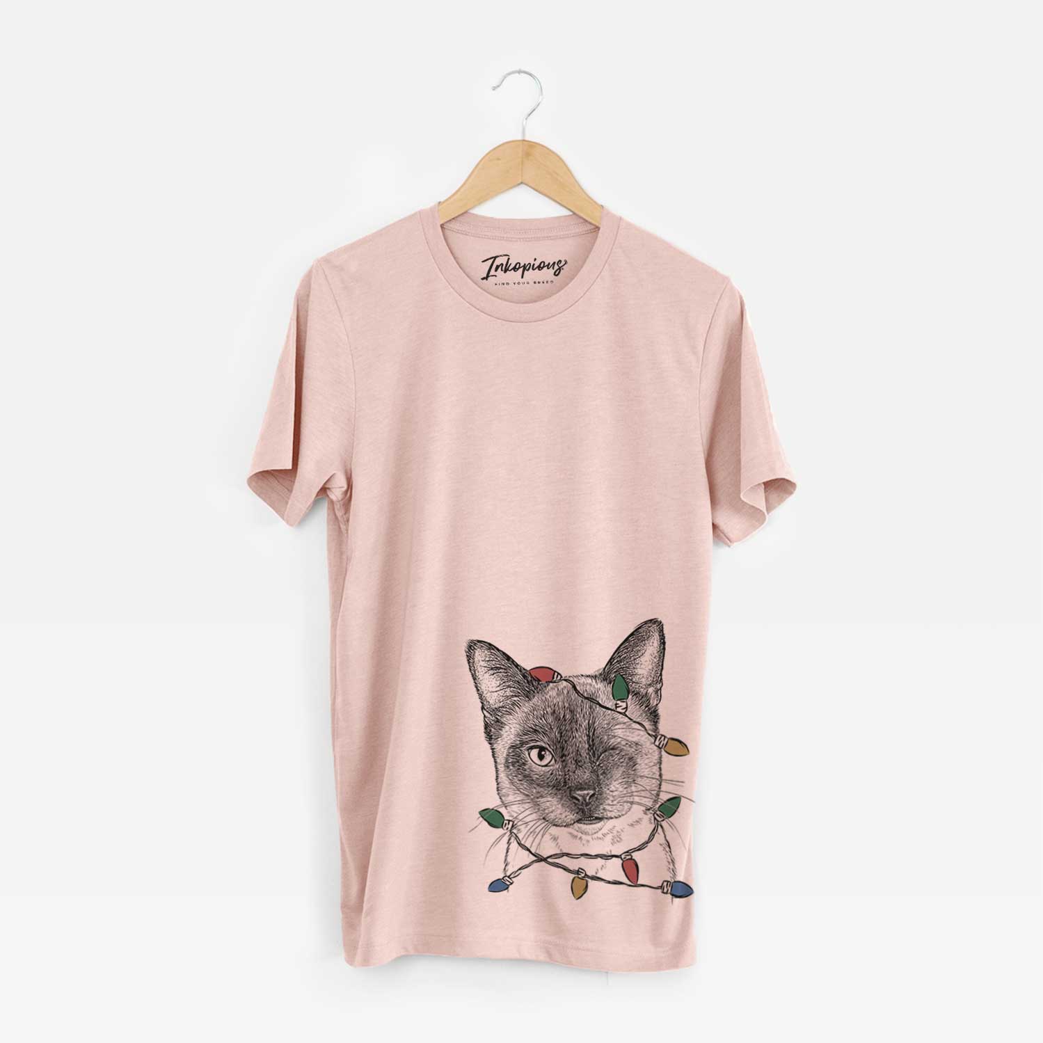 Hand-drawn sketch of Hoggle the Siamese Cat wrapped in Christmas lights on a Peach Unisex crewneck