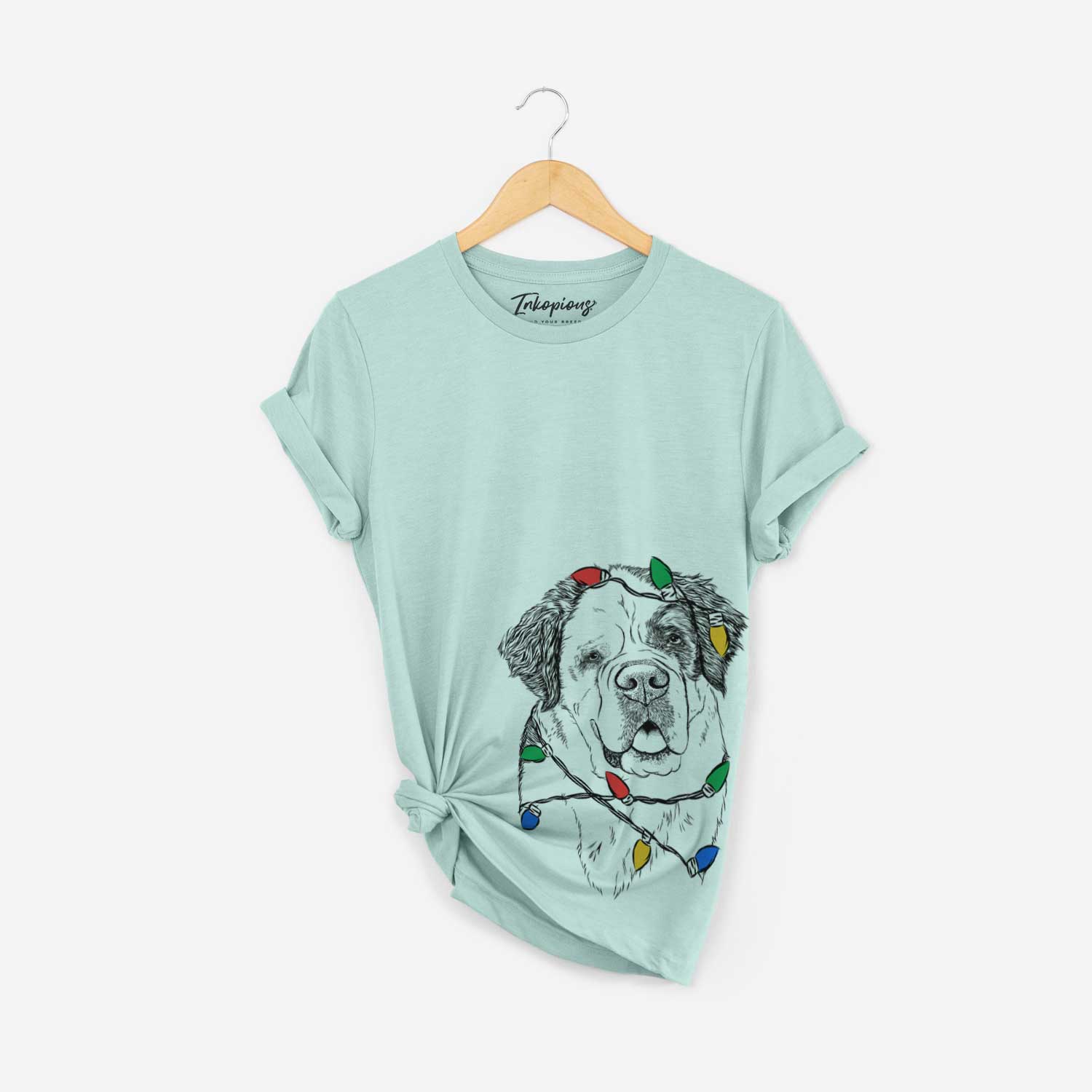 Hand-drawn sketch of Hook the Saint Bernard wrapped in Christmas lights on a Heather Sage Unisex crewneck