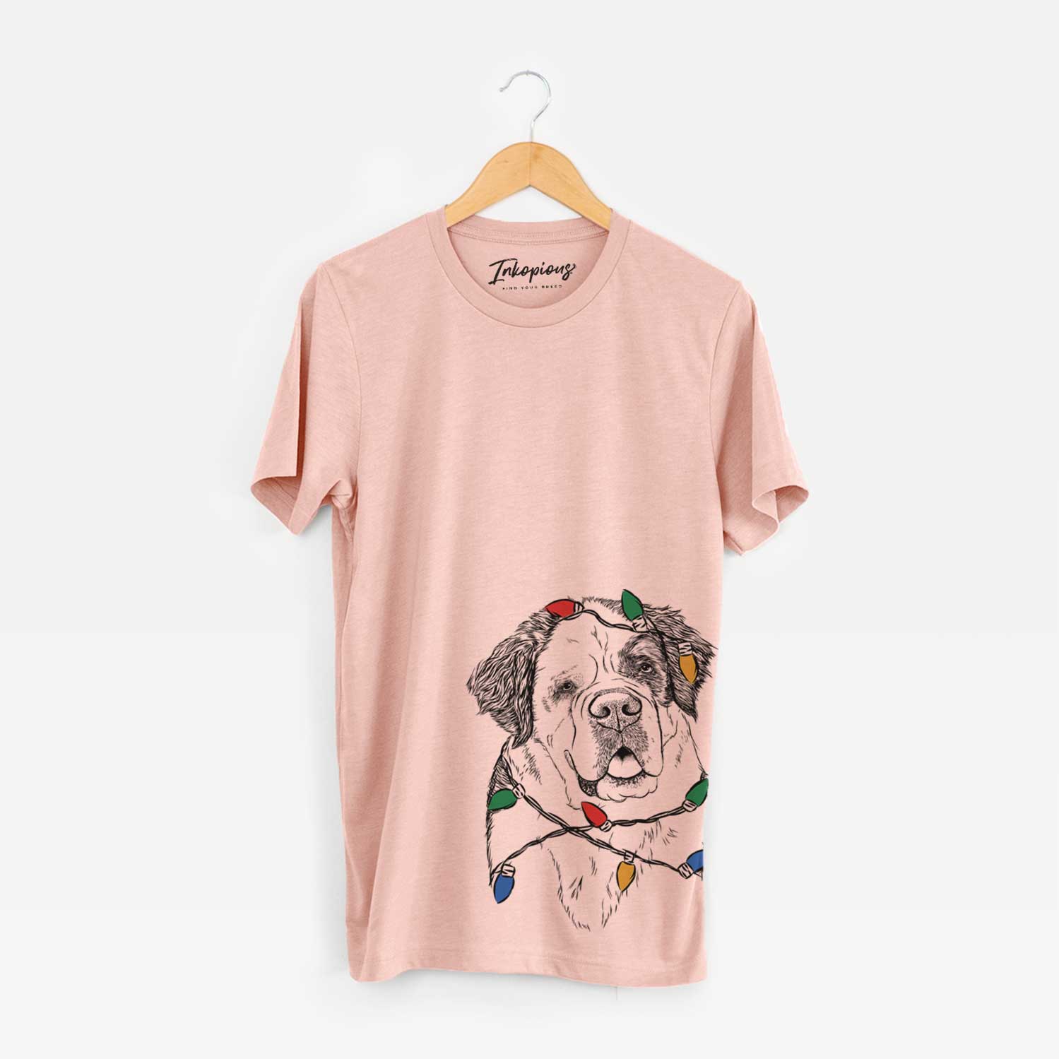 Hand-drawn sketch of Hook the Saint Bernard wrapped in Christmas lights on a Peach Unisex crewneck