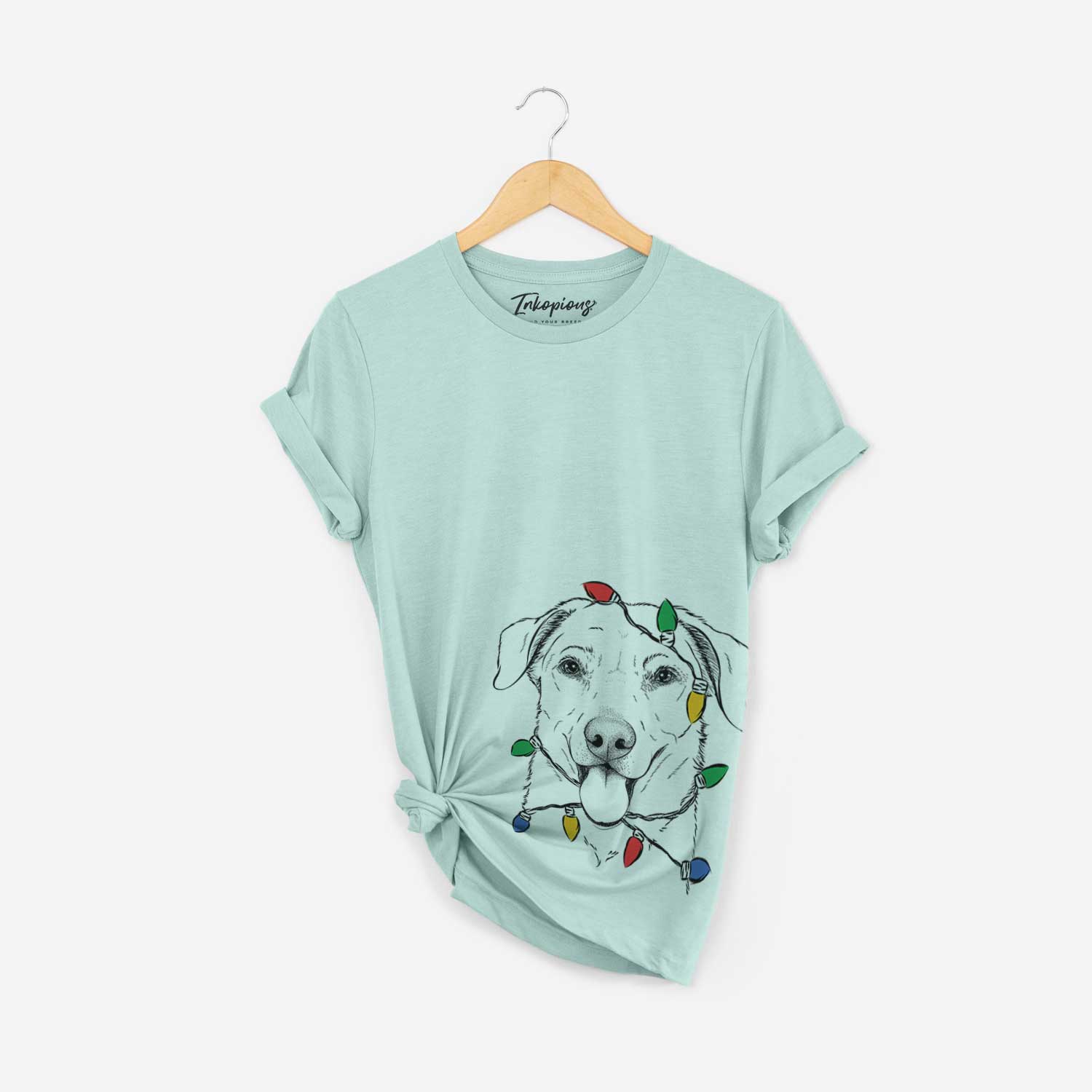 Hand-drawn sketch of Hudson the Shepherd wrapped in Christmas lights on a Heather Sage Unisex crewneck