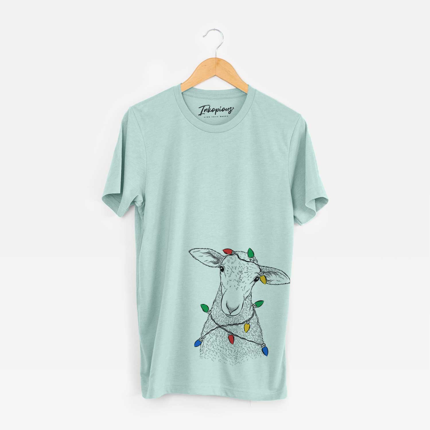 Hand-drawn sketch of Ivy the Lamb wrapped in Christmas lights on a Heather Sage Unisex crewneck