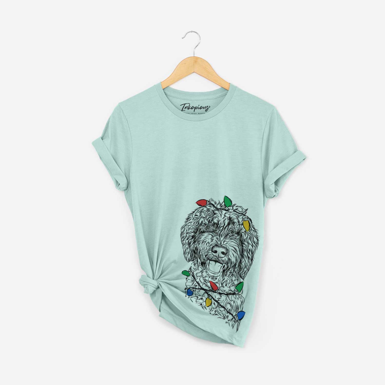 Hand-drawn sketch of Jack the Chocolate Labradoodle wrapped in Christmas lights on a Heather Sage Unisex crewneck