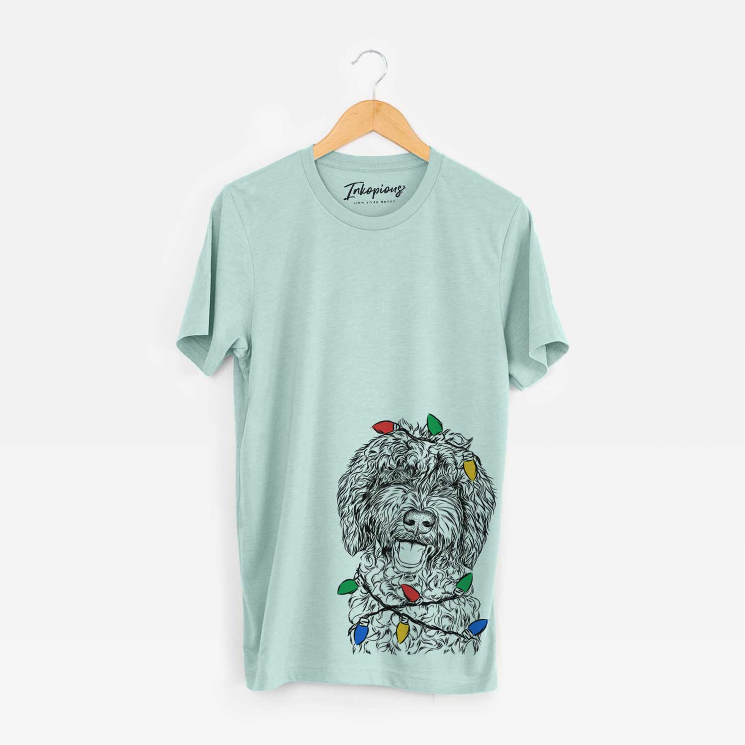 Hand-drawn sketch of Jack the Chocolate Labradoodle wrapped in Christmas lights on a Heather Sage Unisex crewneck