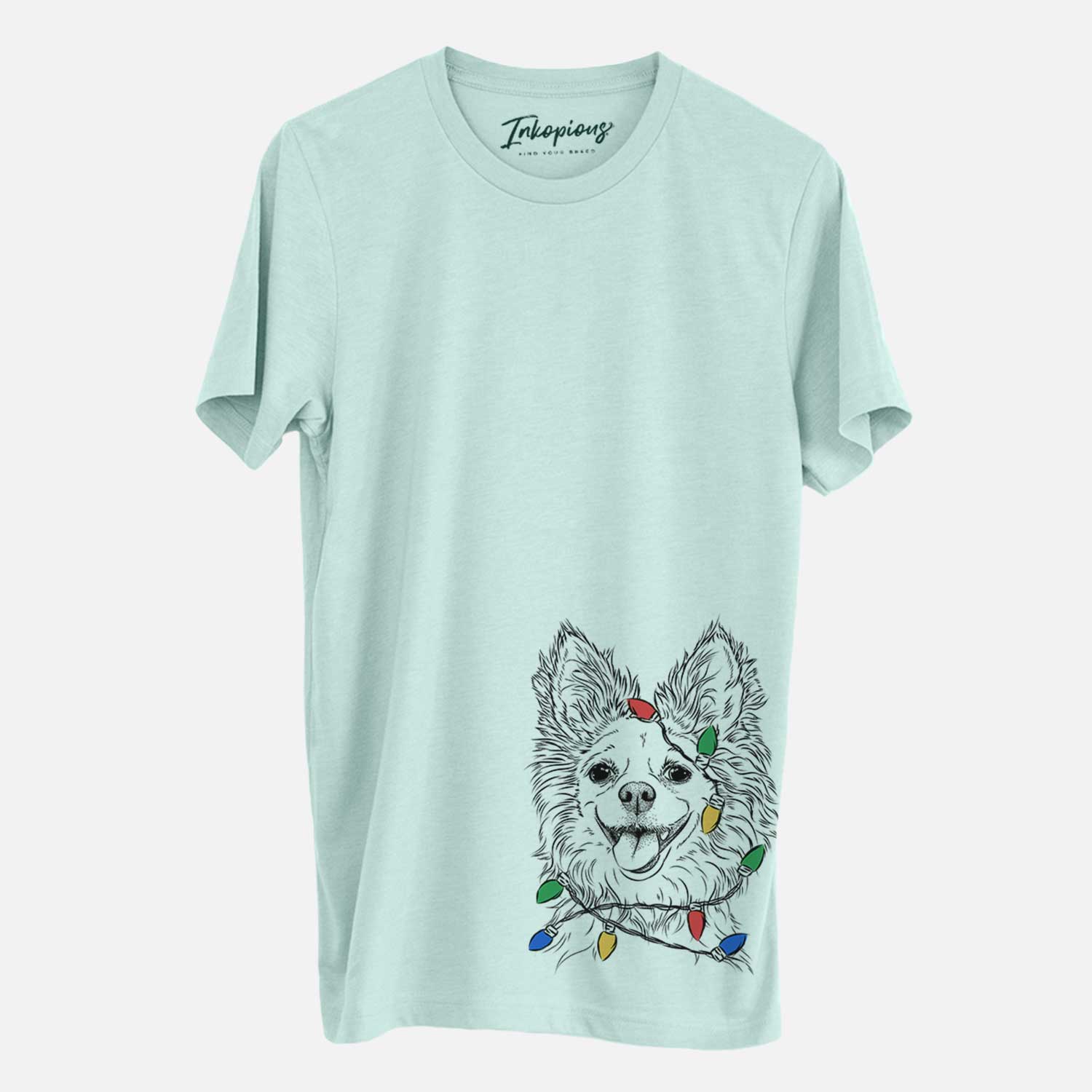 Hand-drawn sketch of Jasper the Pomchi wrapped in Christmas lights on a Heather Sage Unisex crewneck