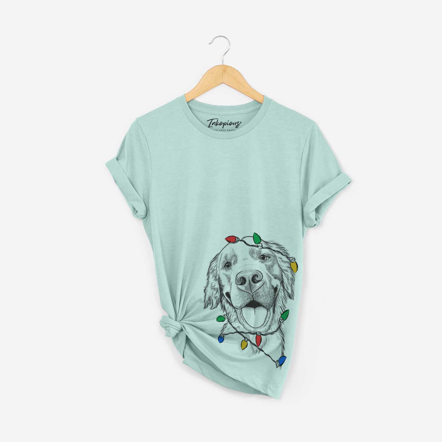 Hand-drawn sketch of Jordy the Golden Retriever wrapped in Christmas lights on a Heather Sage Unisex crewneck