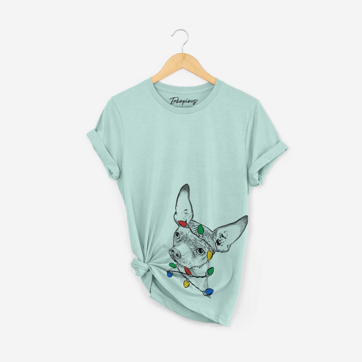 Hand-drawn sketch of Kahlo the Xoloitzcuintli wrapped in Christmas lights on a Heather Sage Unisex crewneck