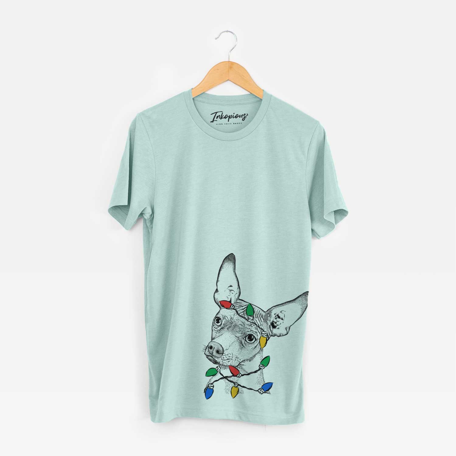 Hand-drawn sketch of Kahlo the Xoloitzcuintli wrapped in Christmas lights on a Heather Sage Unisex crewneck