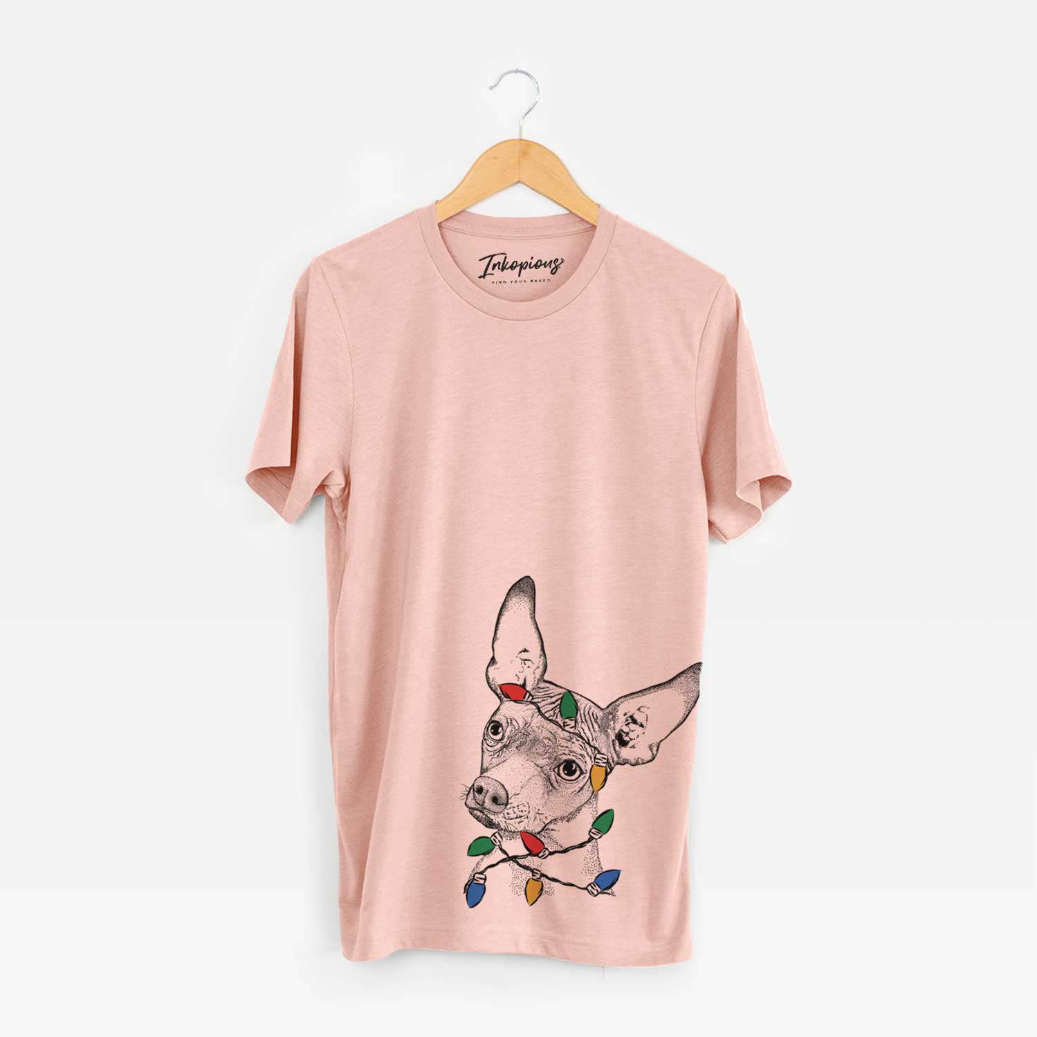 Hand-drawn sketch of Kahlo the Xoloitzcuintli wrapped in Christmas lights on a Peach Unisex crewneck