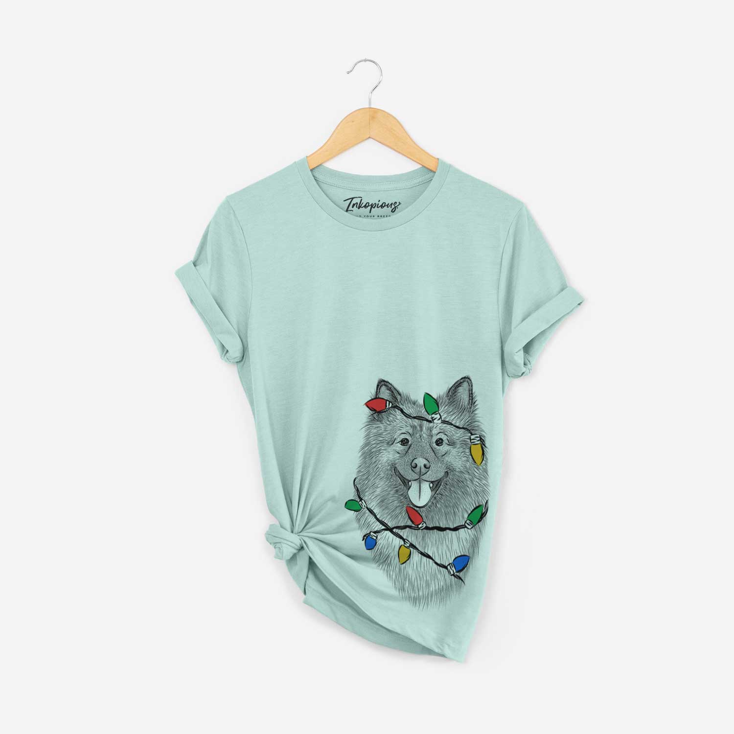 Hand-drawn sketch of Kai the Keeshond wrapped in Christmas lights on a Heather Sage Unisex crewneck