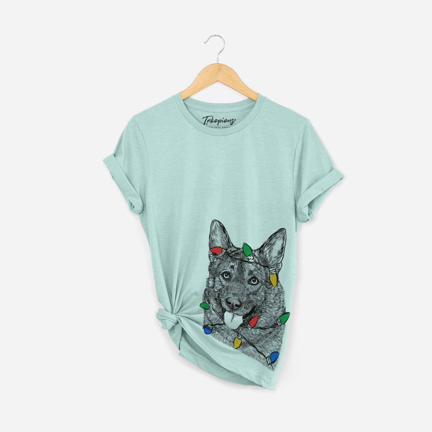 Hand-drawn sketch of Kasia the Norwegian Elkhound wrapped in Christmas lights on a Heather Sage Unisex crewneck