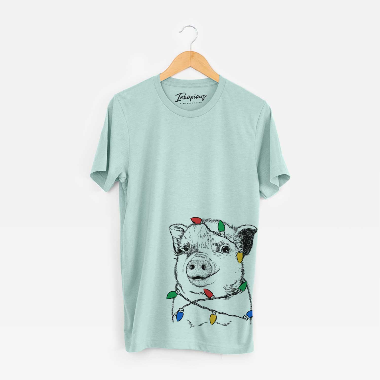 Hand-drawn sketch of Kevin the Spotted Pig wrapped in Christmas lights on a Heather Sage Unisex crewneck