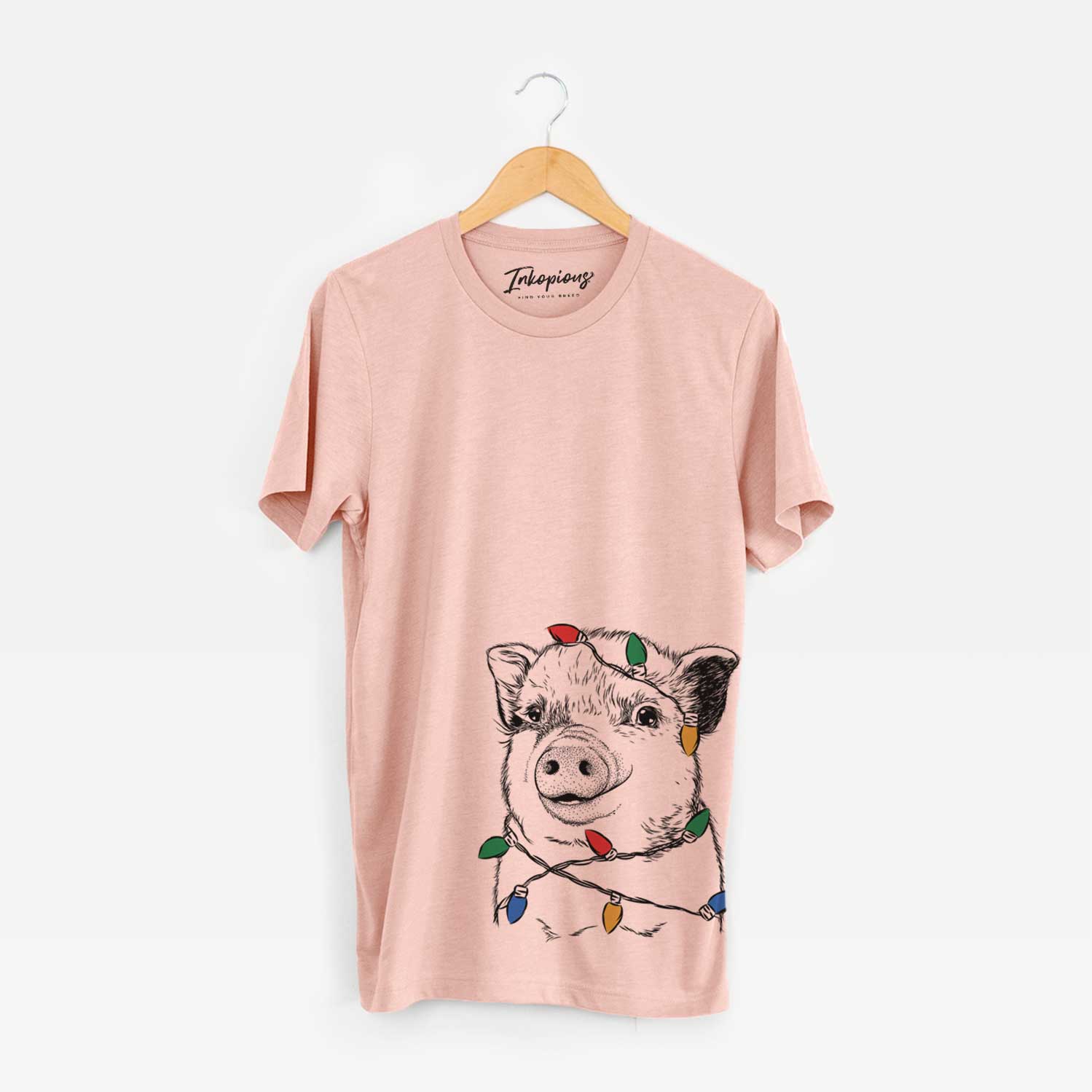 Hand-drawn sketch of Kevin the Spotted Pig wrapped in Christmas lights on a Peach Unisex crewneck