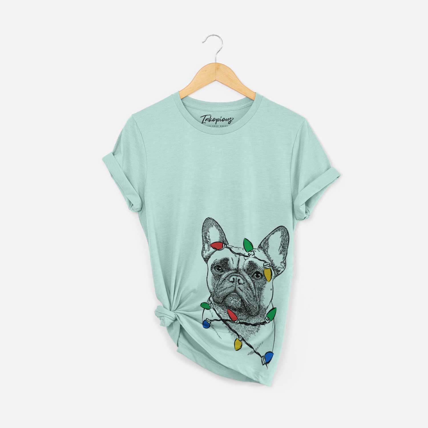 Hand-drawn sketch of Kingsleigh the French Bulldog wrapped in Christmas lights on a Heather Sage Unisex crewneck