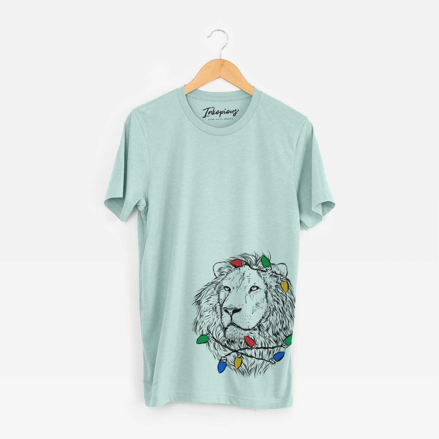 Hand-drawn sketch of Lenny the Lion wrapped in Christmas lights on a Heather Sage Unisex crewneck