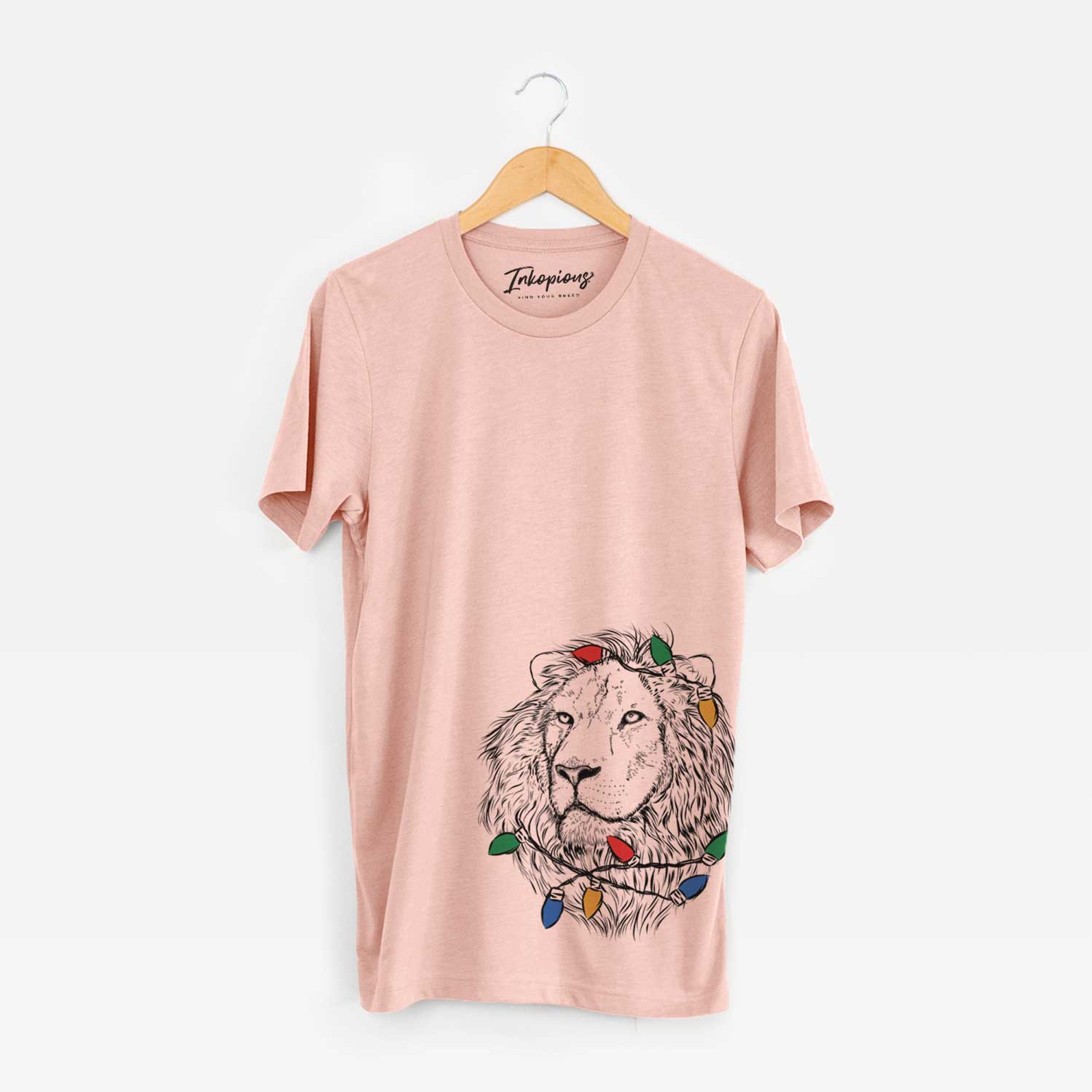 Hand-drawn sketch of Lenny the Lion wrapped in Christmas lights on a Peach Unisex crewneck