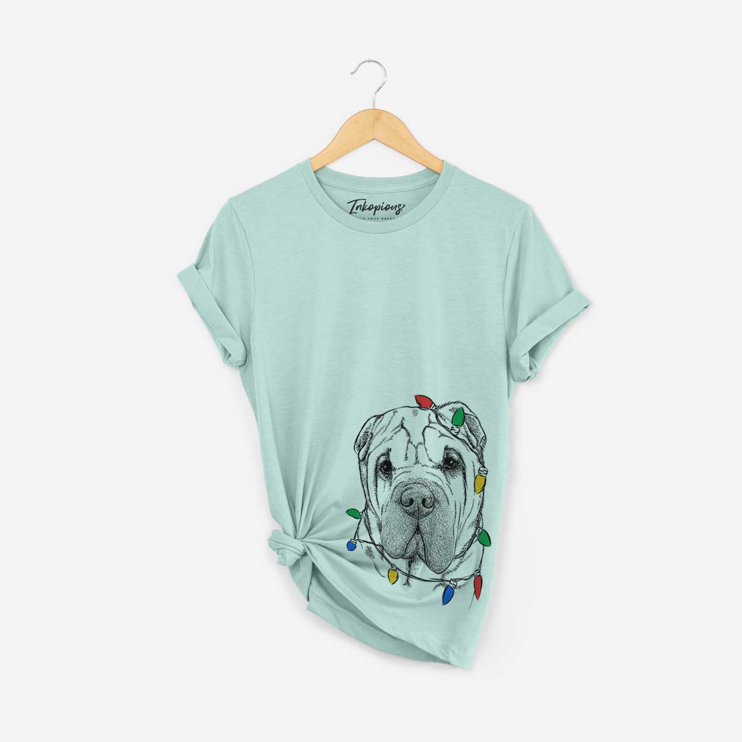 Hand-drawn sketch of Lilly the Shar Pei wrapped in Christmas lights on a Heather Sage Unisex crewneck