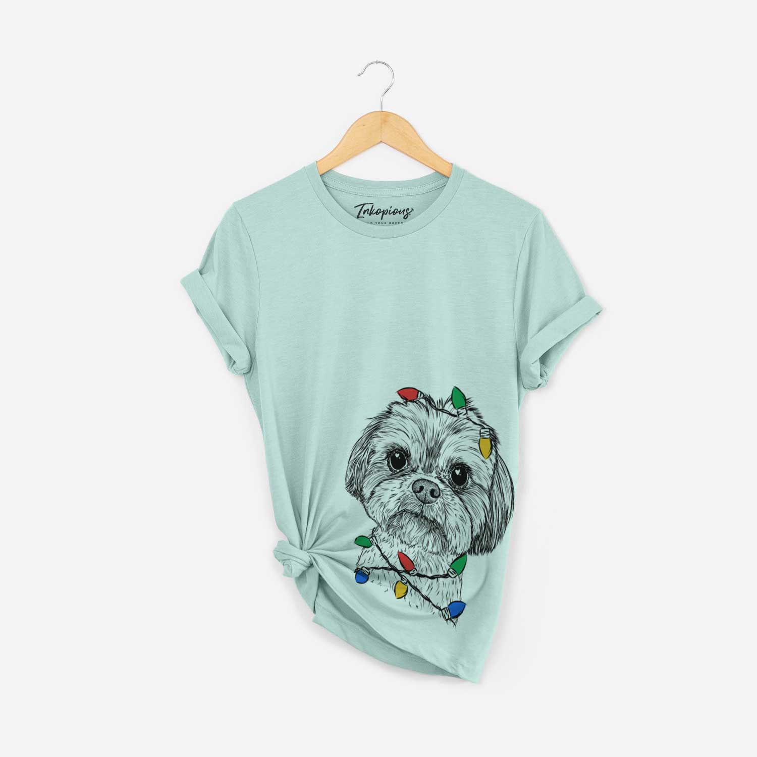 Hand-drawn sketch of Lucy the Shorkie wrapped in Christmas lights on a Heather Sage Unisex crewneck