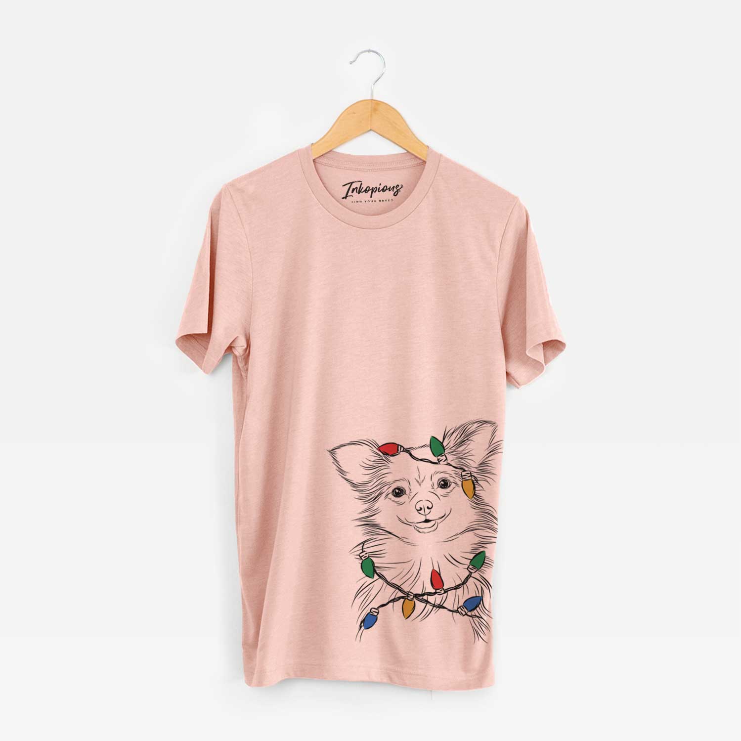 Hand-drawn sketch of Marzi the Long Haired Chihuahua wrapped in Christmas lights on a Peach Unisex crewneck