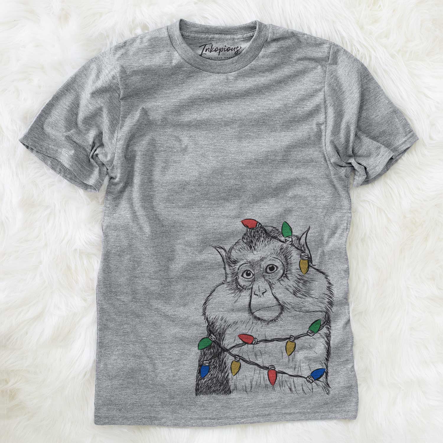 Hand-drawn sketch of Matata the Mona Monkey wrapped in Christmas lights on a Grey Unisex crewneck
