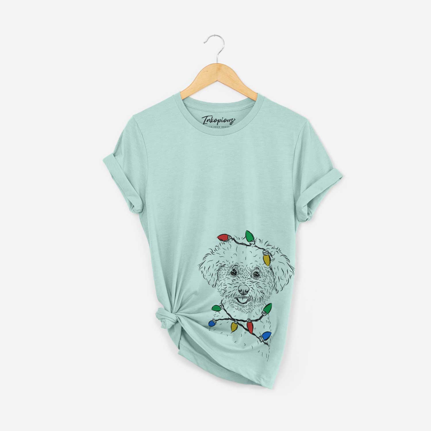 Hand-drawn sketch of Mickey the Bichon Frise wrapped in Christmas lights on a Heather Sage Unisex crewneck