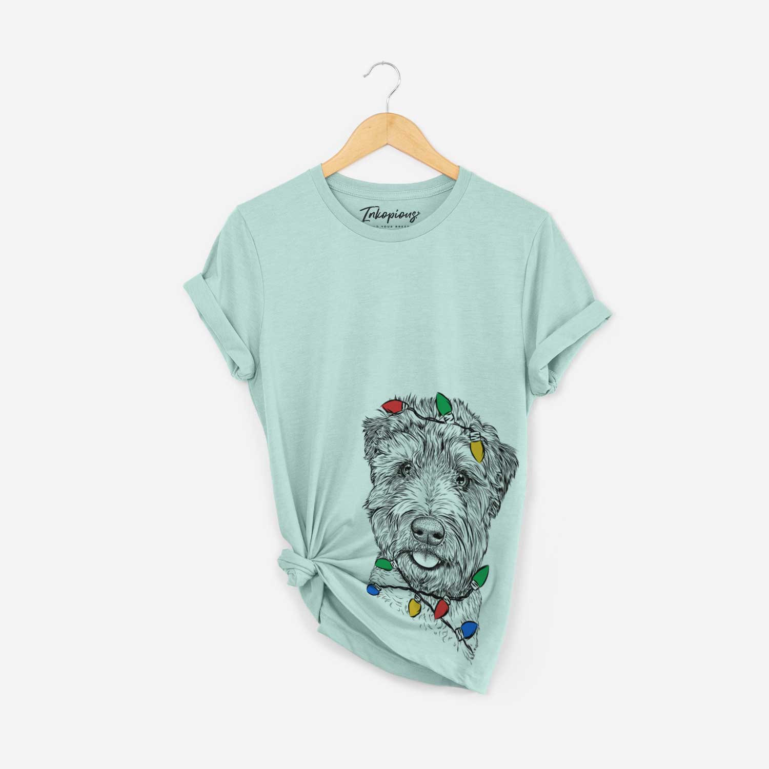 Hand-drawn sketch of Milton the Soft Coated Wheaten Terrier wrapped in Christmas lights on a Heather Sage Unisex crewneck