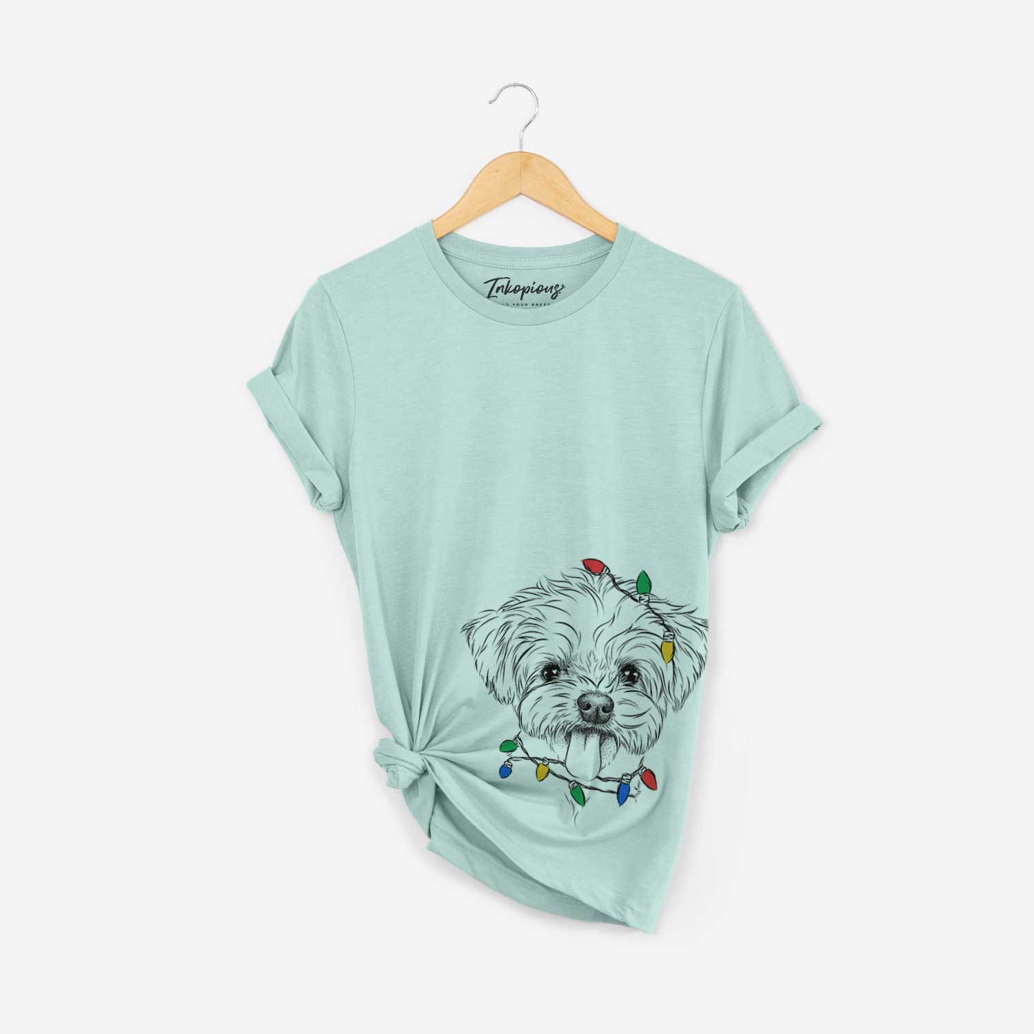 Hand-drawn sketch of Mochi the Maltese wrapped in Christmas lights on a Heather Sage Unisex crewneck