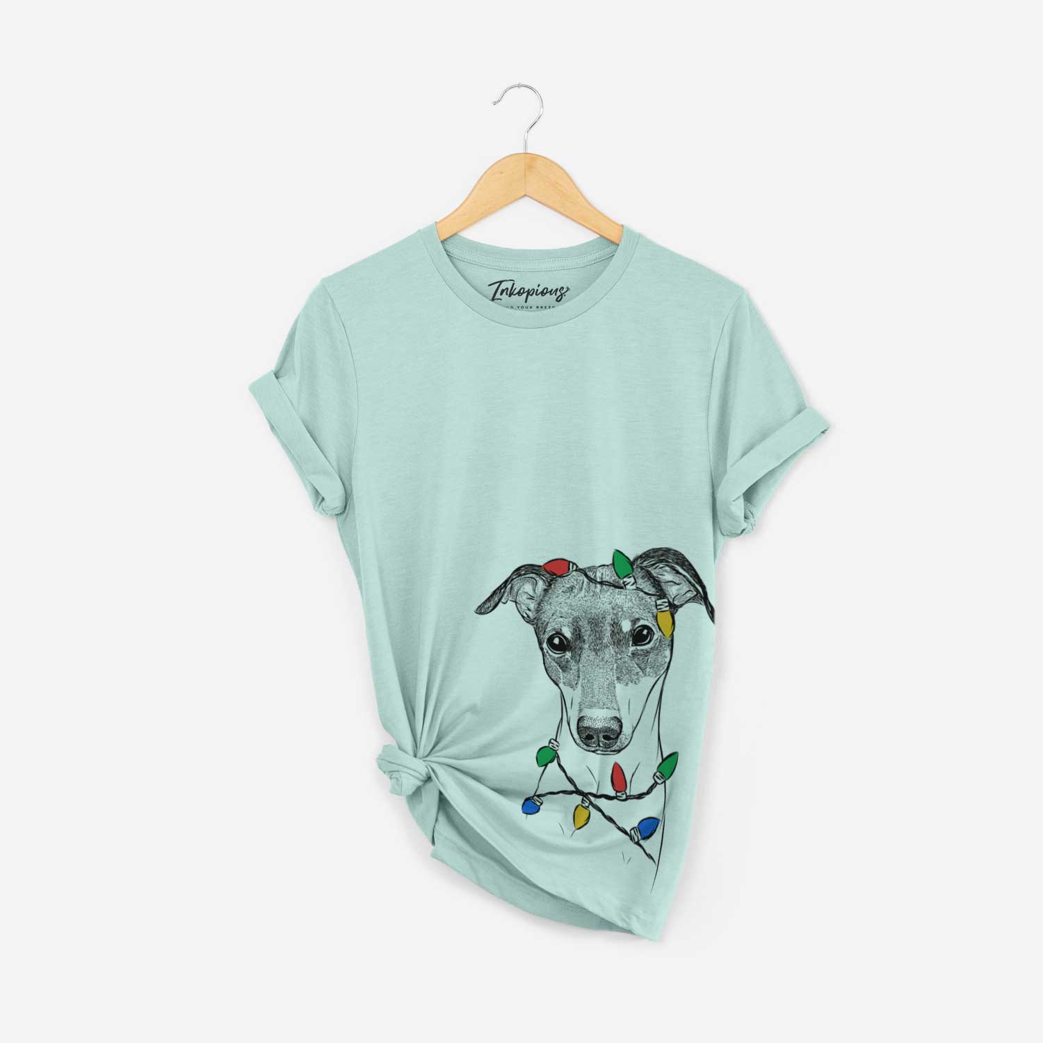 Hand-drawn sketch of Momo the Japanese Terrier wrapped in Christmas lights on a Heather Sage Unisex crewneck