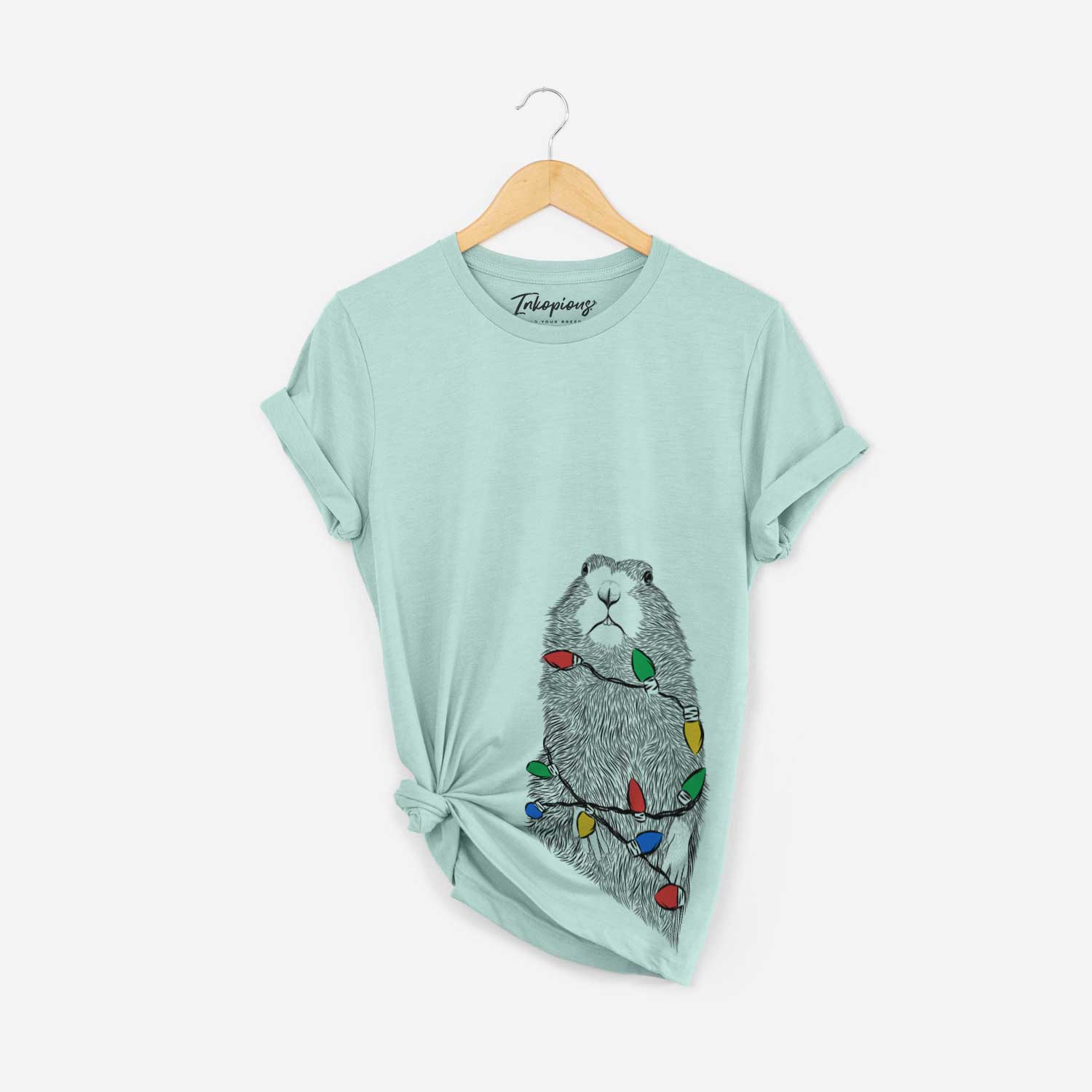 Hand-drawn sketch of Mr. Otis the Prairie Dog wrapped in Christmas lights on a Heather Sage Unisex crewneck