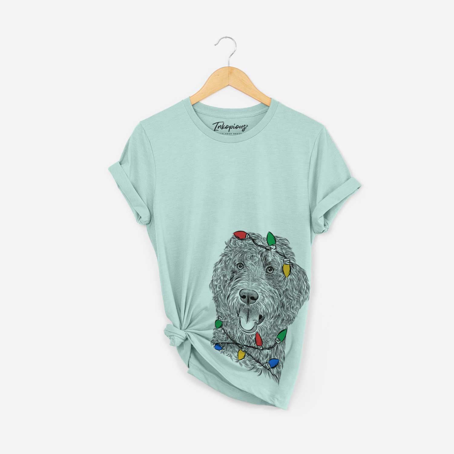 Hand-drawn sketch of Murr Dog the Labradoodle wrapped in Christmas lights on a Heather Sage Unisex crewneck