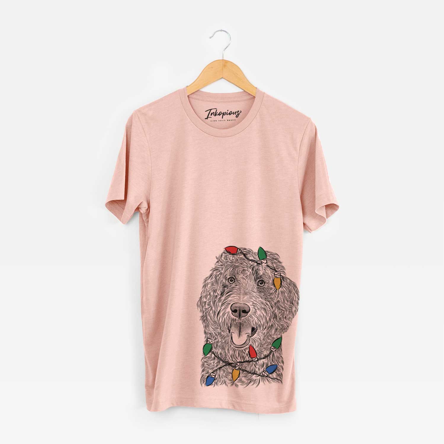 Hand-drawn sketch of Murr Dog the Labradoodle wrapped in Christmas lights on a Peach Unisex crewneck