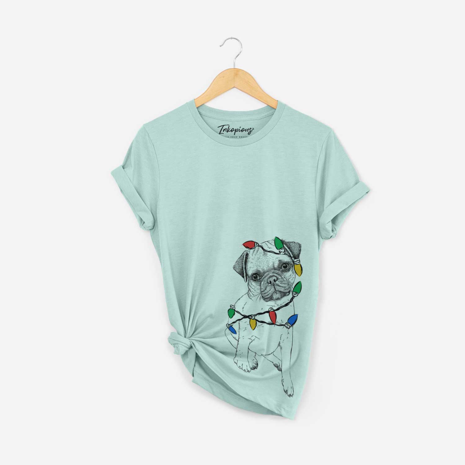 Hand-drawn sketch of Nelson the Pug Puppy wrapped in Christmas lights on a Heather Sage Unisex crewneck