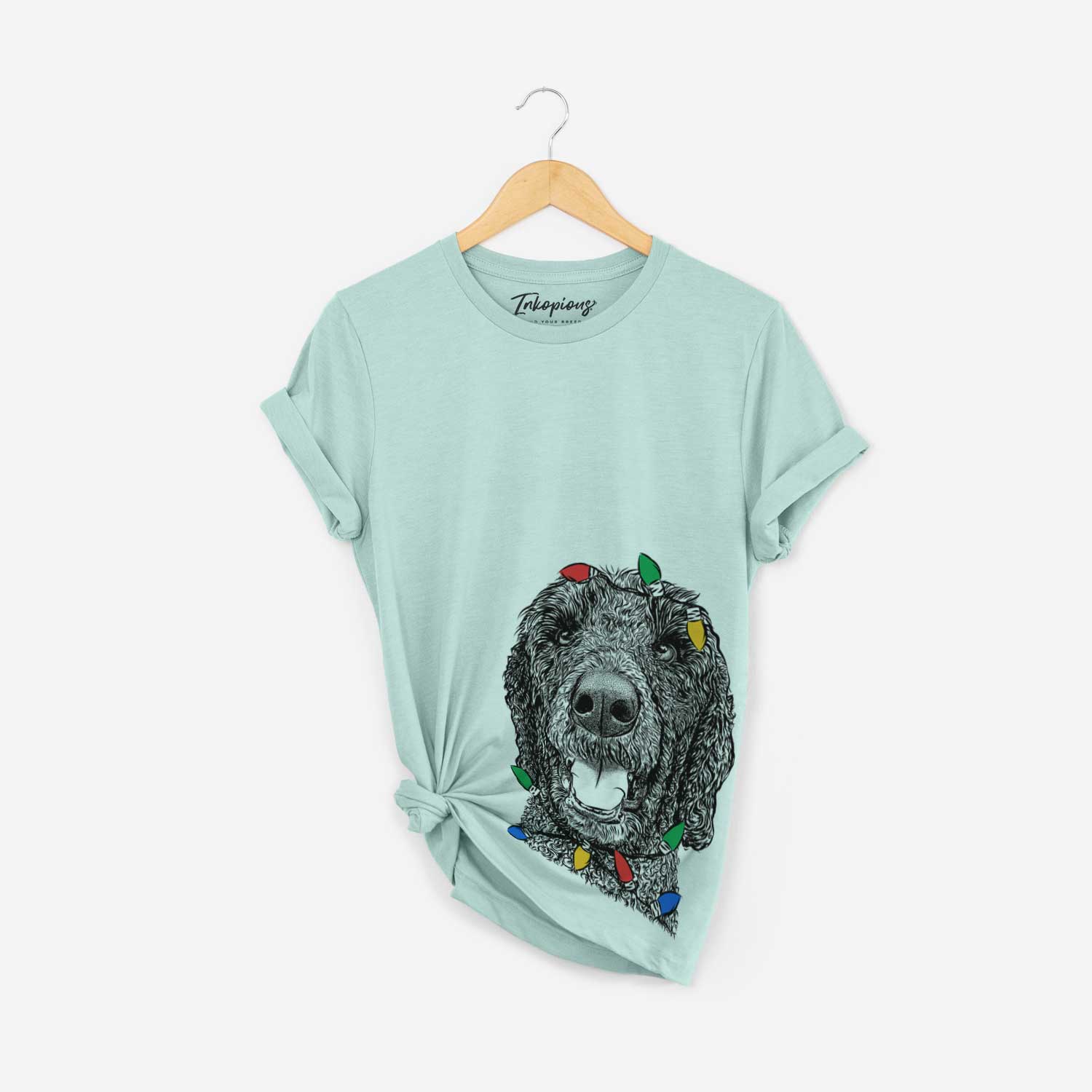 Hand-drawn sketch of Obi James the Goldendoodle wrapped in Christmas lights on a Heather Sage Unisex crewneck