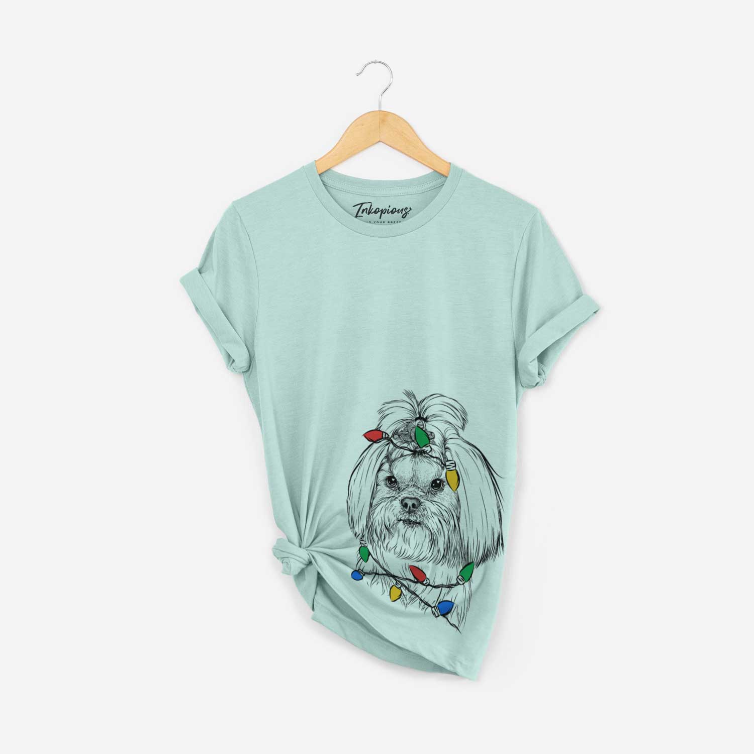 Hand-drawn sketch of Olga the Shih Tzu wrapped in Christmas lights on a Heather Sage Unisex crewneck